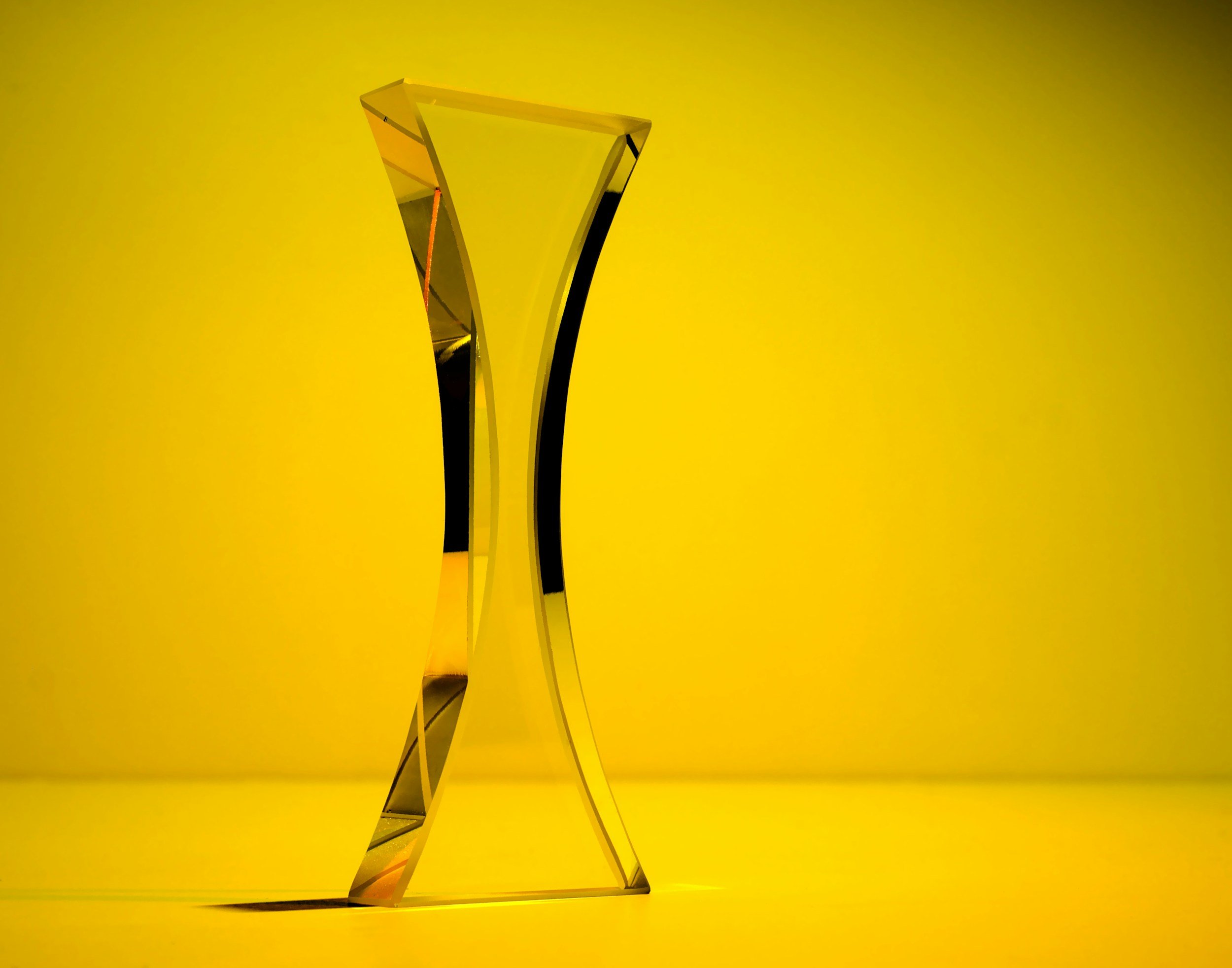 Golden award trophy on a yellow background.