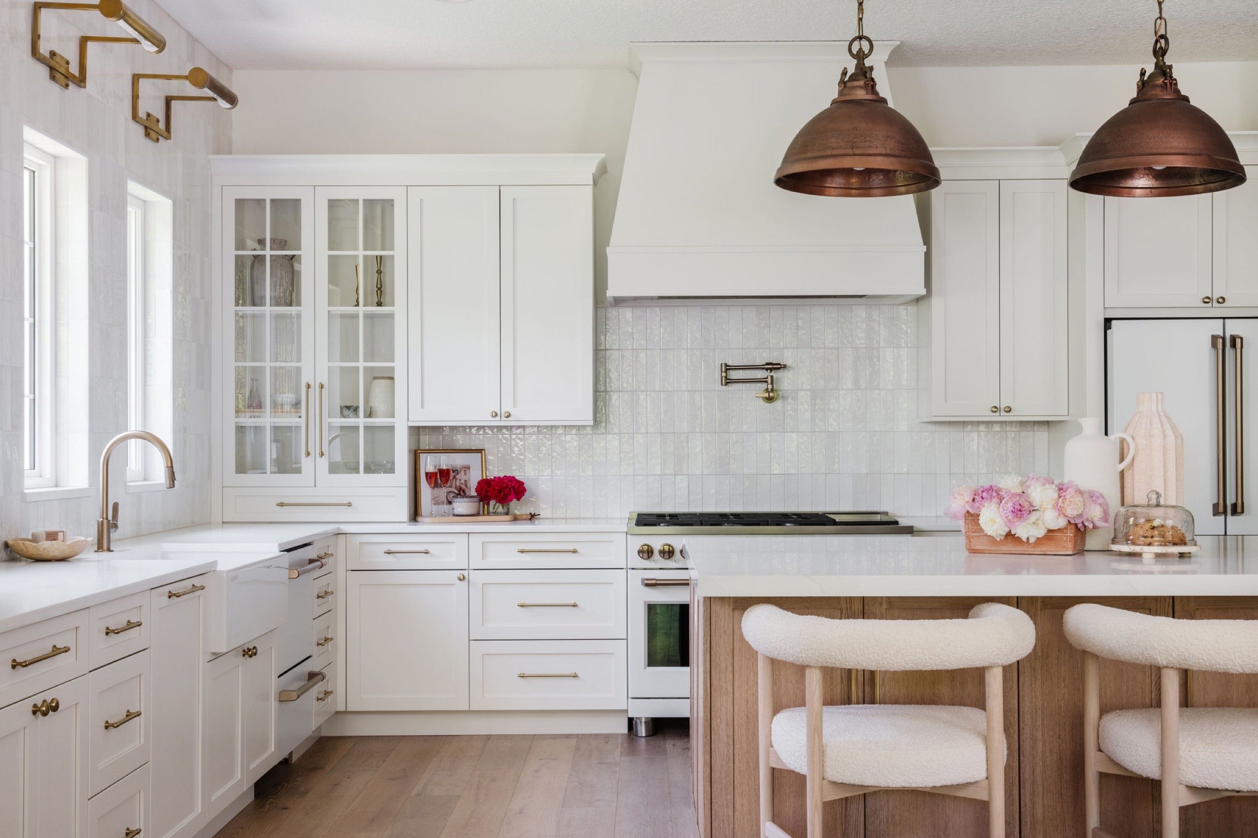 A kitchen with white cabinets and gold accents