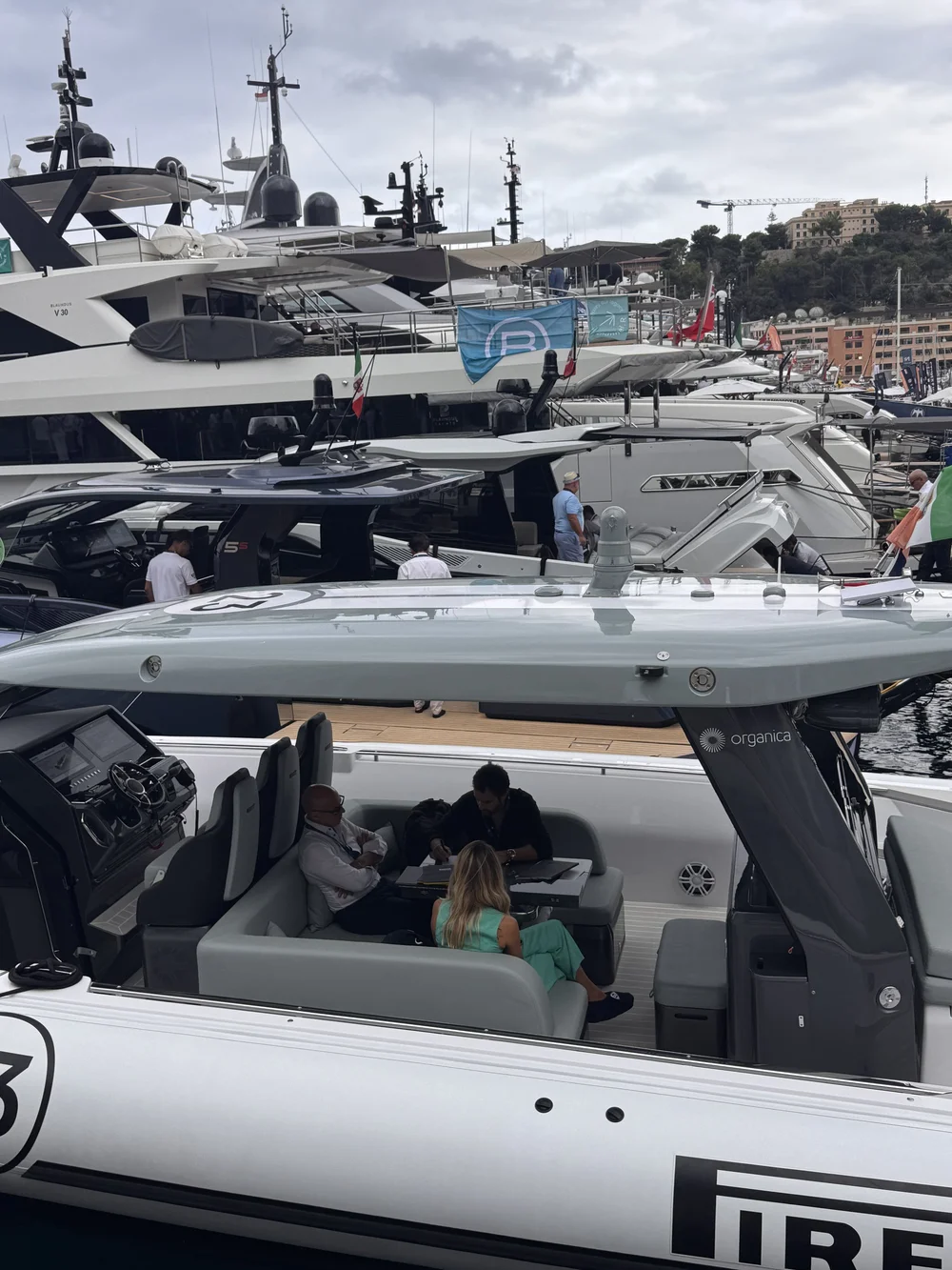 Guests seated in the cockpit of a motor yacht, a tender stowed on the deck above