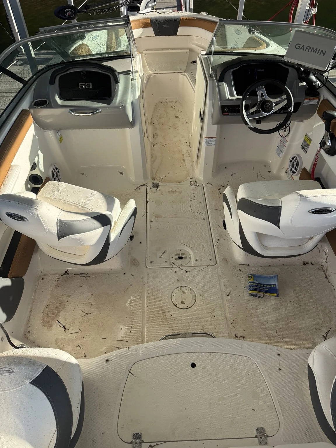 Floor detail before cleaning: leaves, twigs and buildup around cockpit hatches and seating.