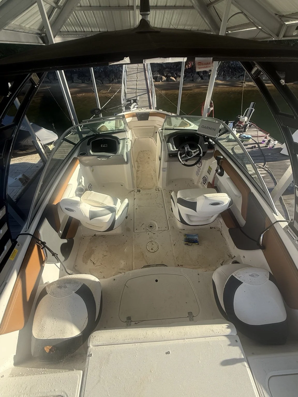 Initial condition: loose debris across the white cockpit floor and marks on seating beneath a covered dock.