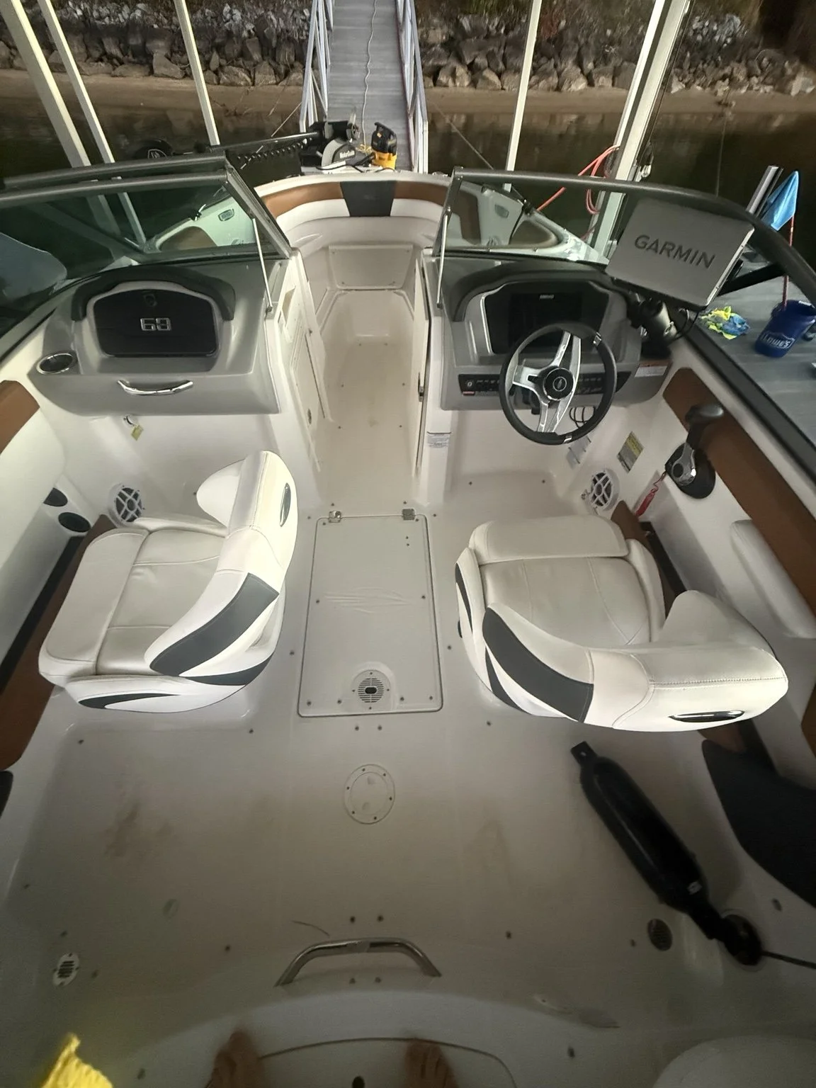 Cleaned cockpit view: white seating, helm and walking surfaces with much of the loose floor debris removed.