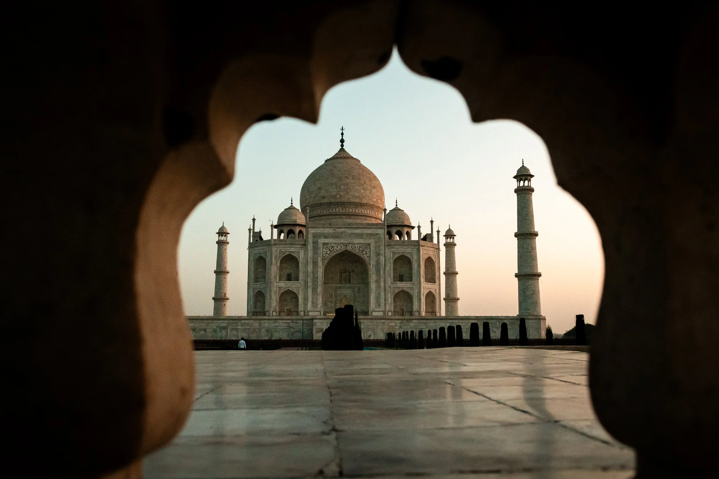 View of the Taj Mahal through a decorative window opening.
