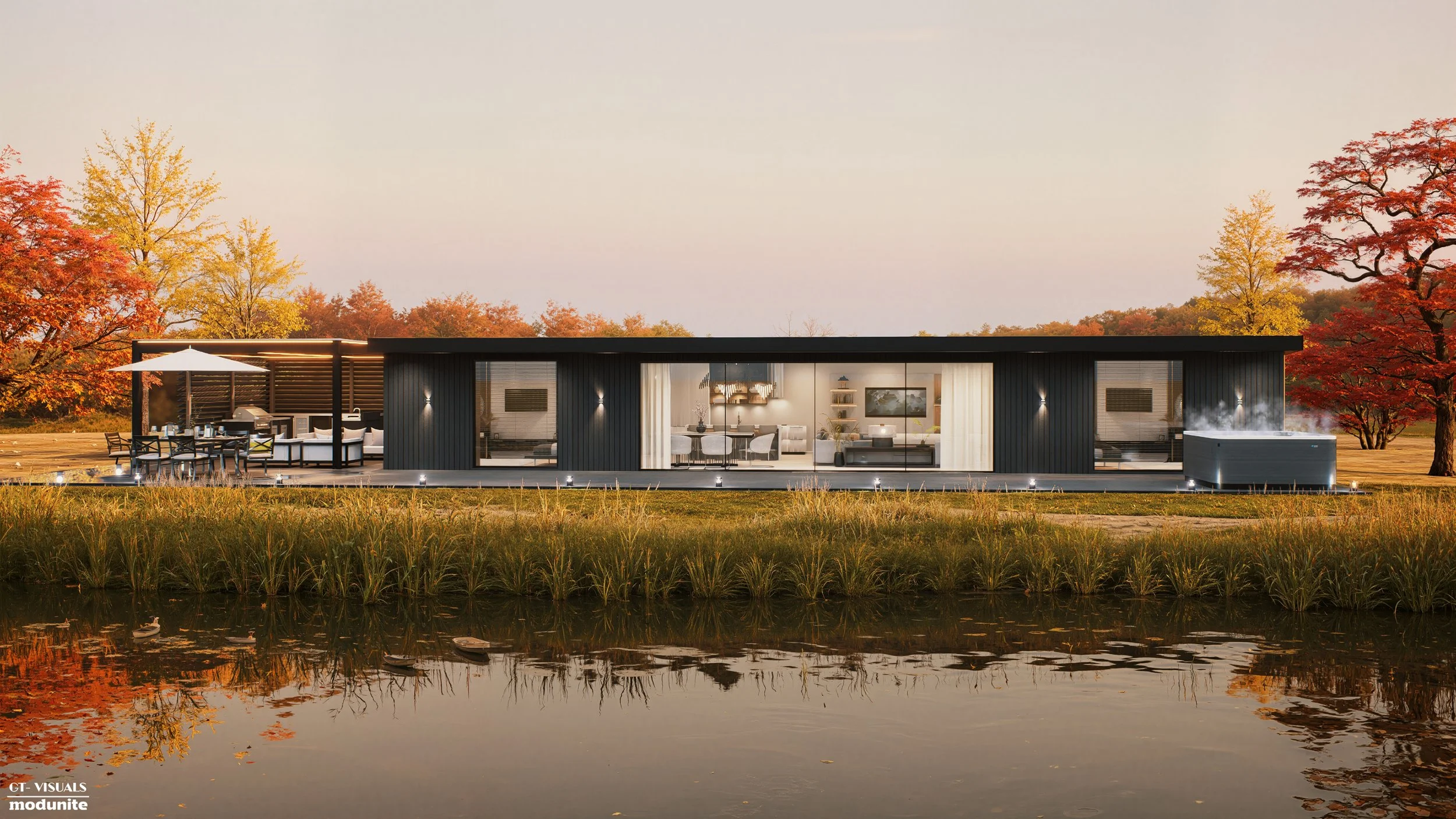 Modern house with large glass windows, outdoor patio with dining and seating area, hot tub, surrounded by trees with fall foliage, reflected in a nearby pond.