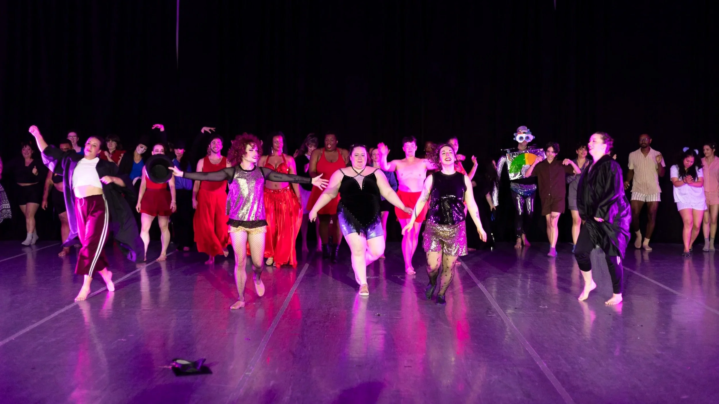 Alyssa, Chris, Amy, and Megan lead a much larger cast forward for a final bow. Dancers wear a variety of costumes.