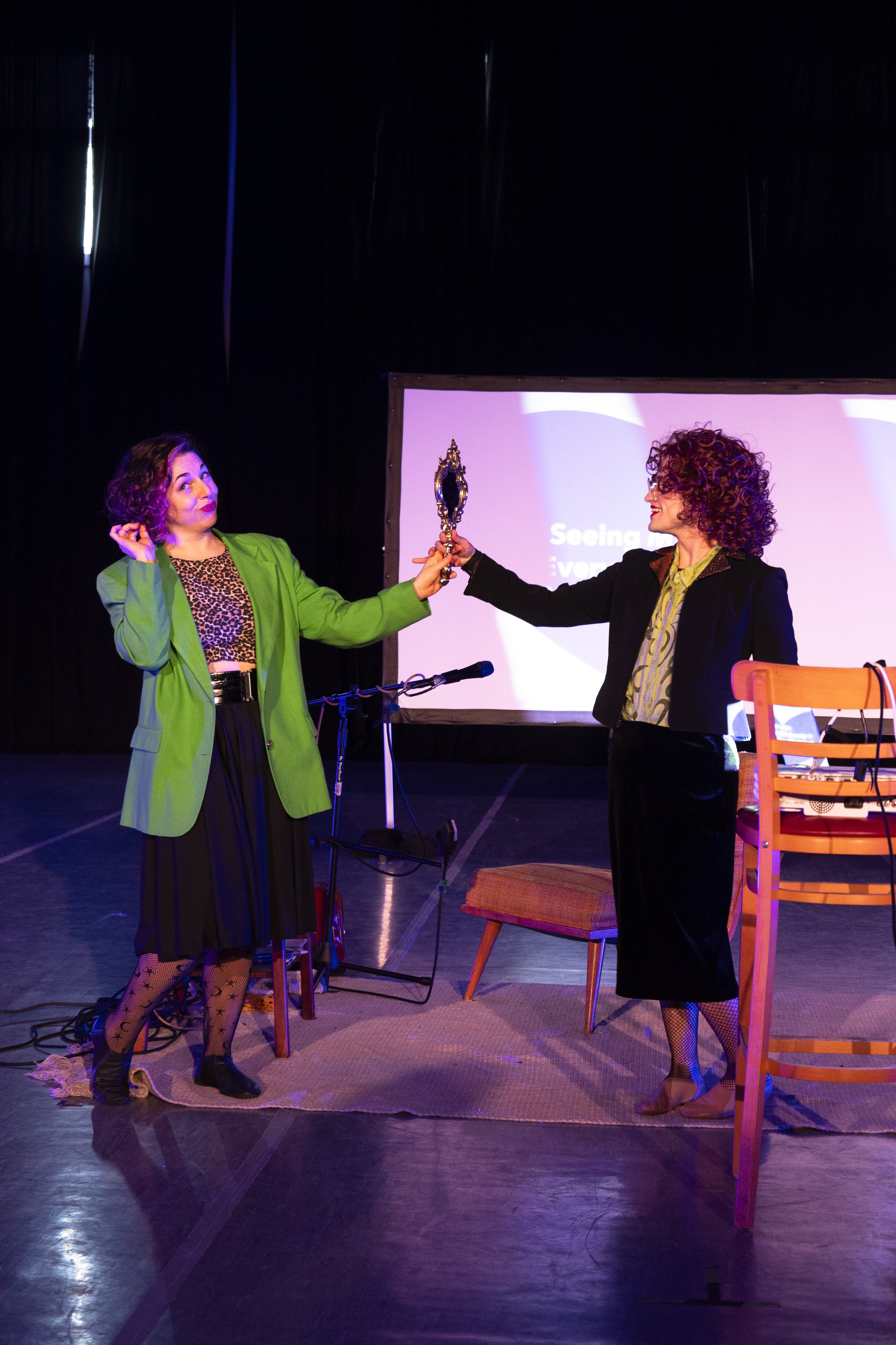 Ms. Victoria looks at the audience keenly while Miss Vikki steals her mirror.