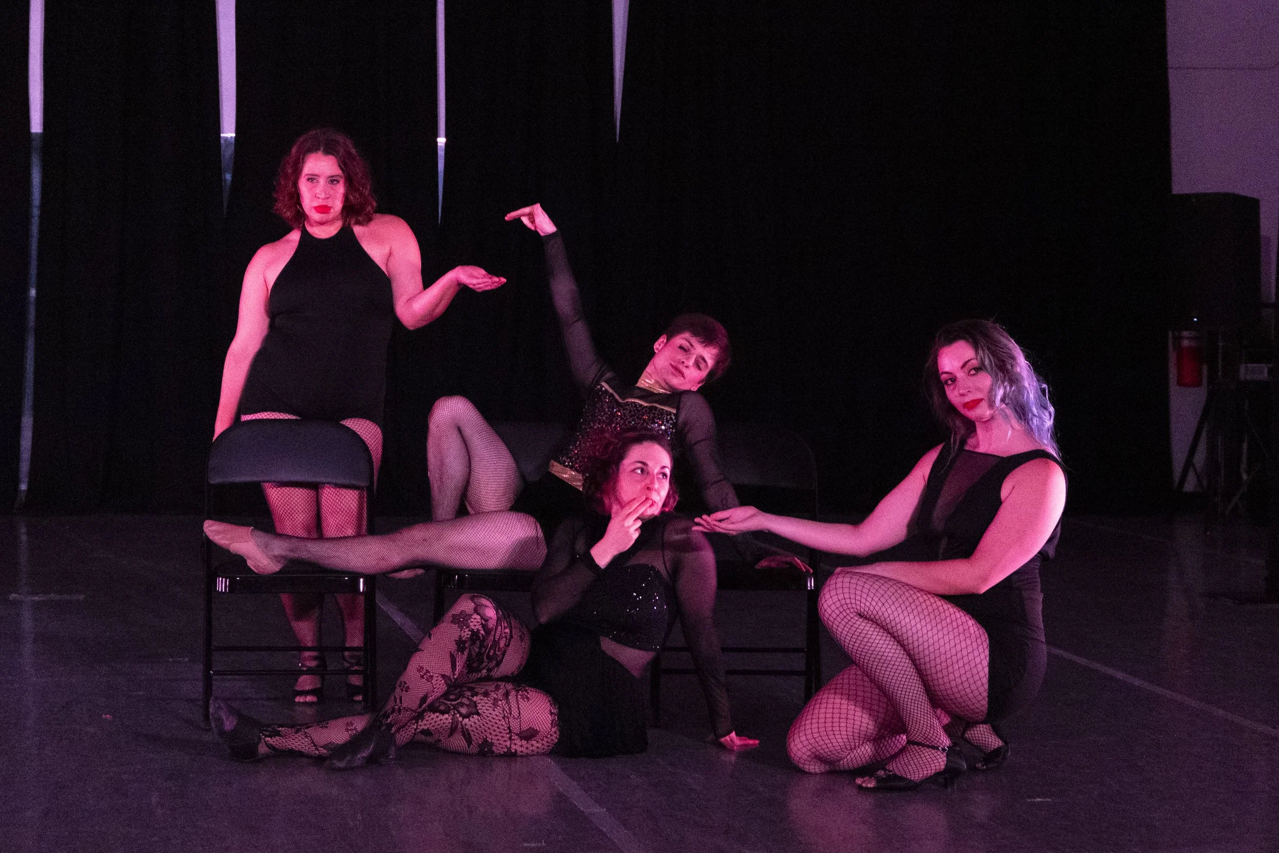 Four dancers take a "smoke break" onstage with air cigarettes. Two dancers smoke and the others present their hands as ashtrays.
