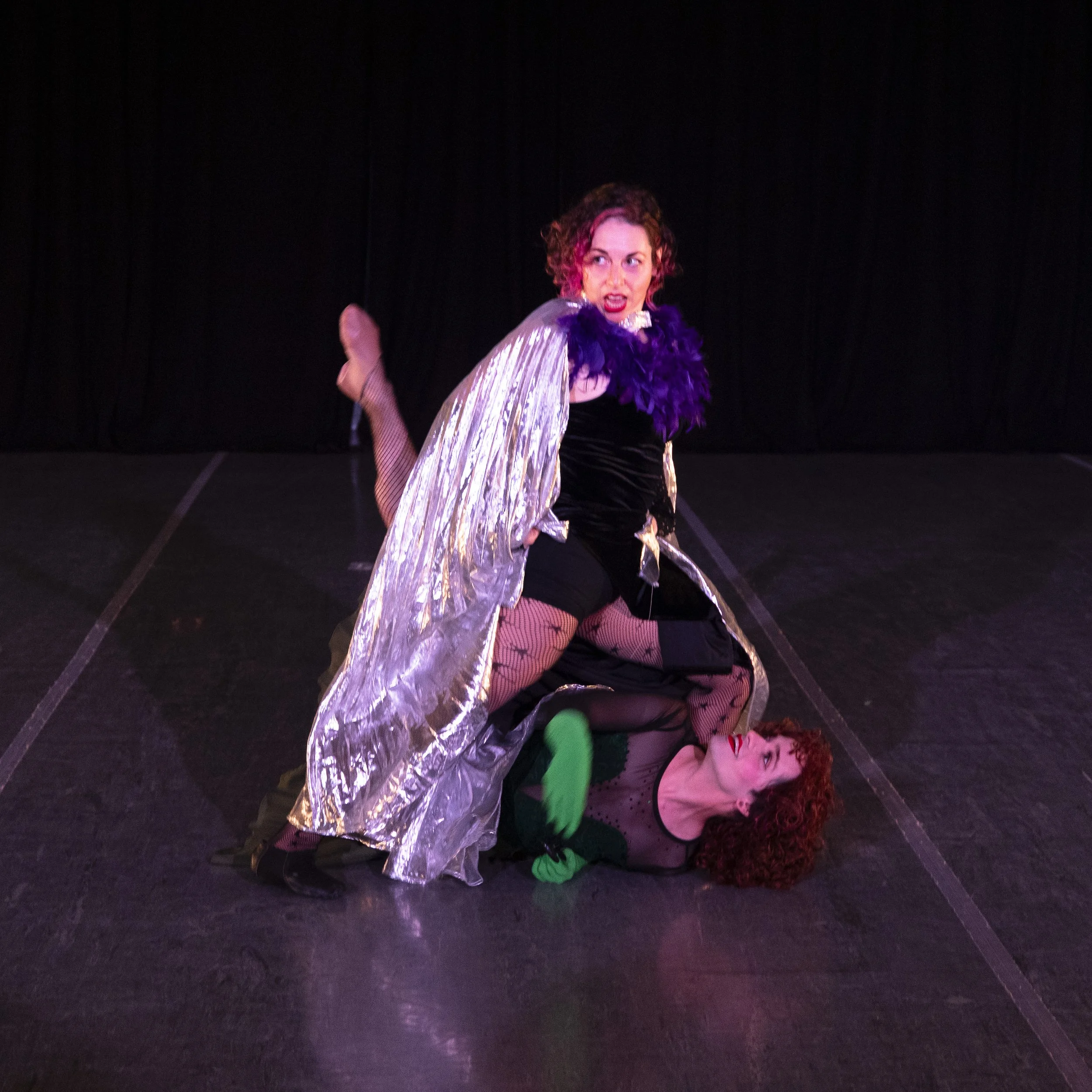Ms. Victoria hits a pose, standing over Miss Vikki on the floor.
