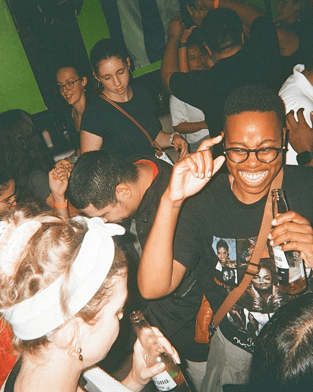 Group of people enjoying a lively party, smiling, drinking beer, and dancing at Lolo's Social Club.