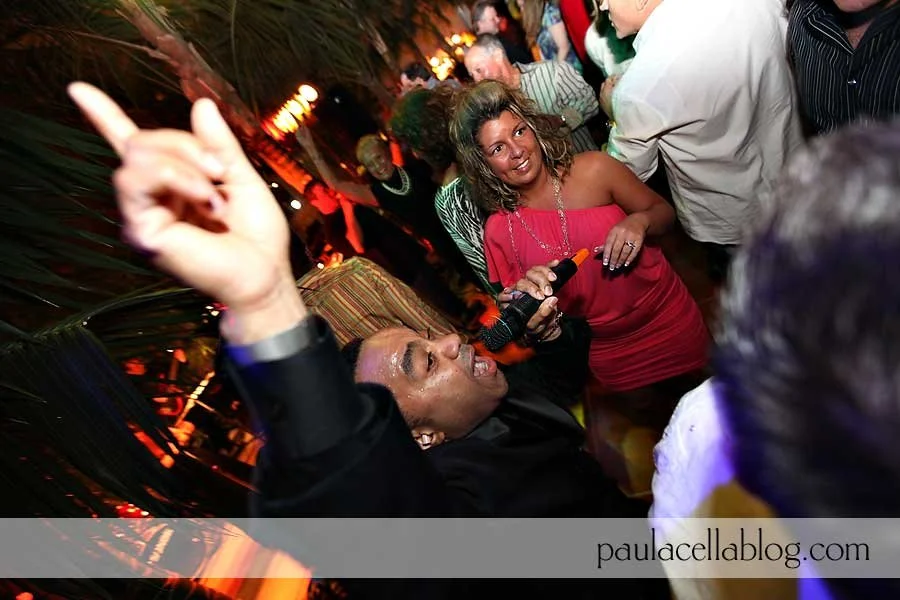 People dancing and socializing at a lively party or nightclub with colorful lighting.