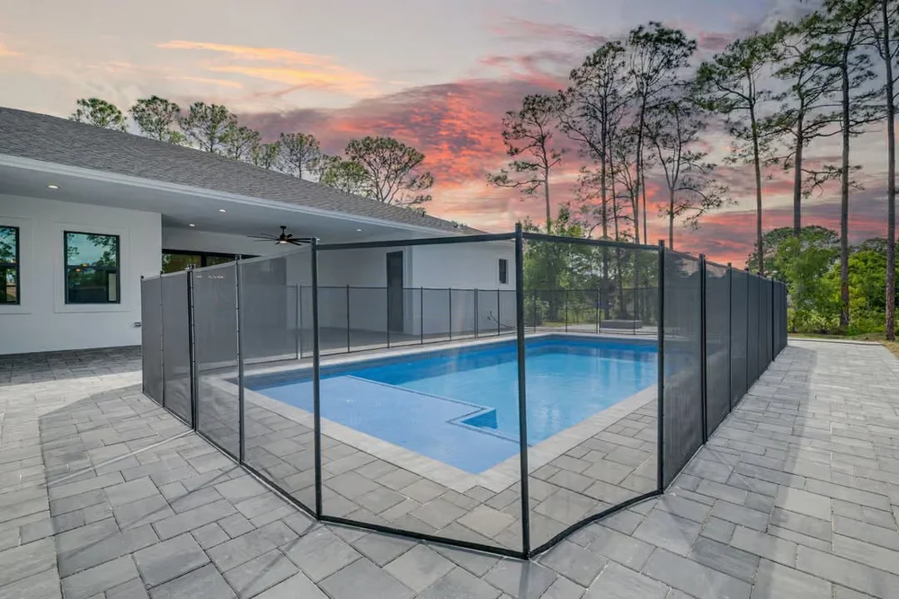 Pool behind a new home at sunset