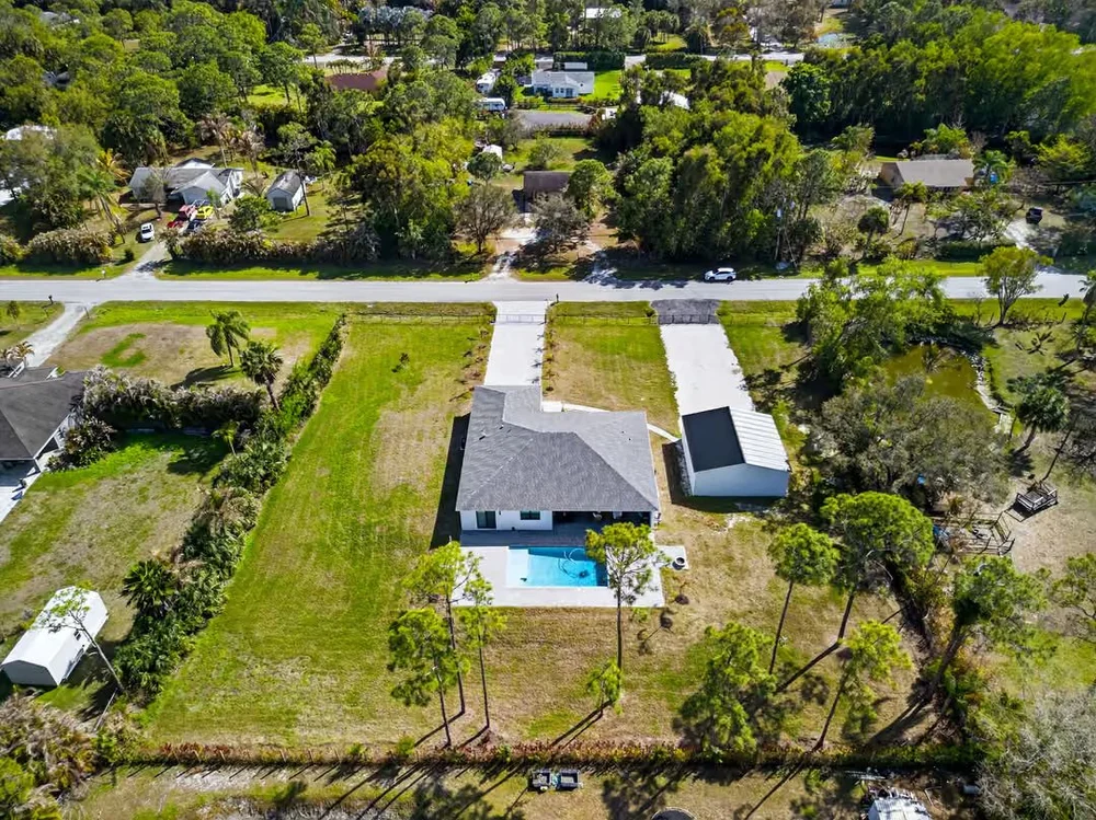Aerial view of a new-construction home with pool