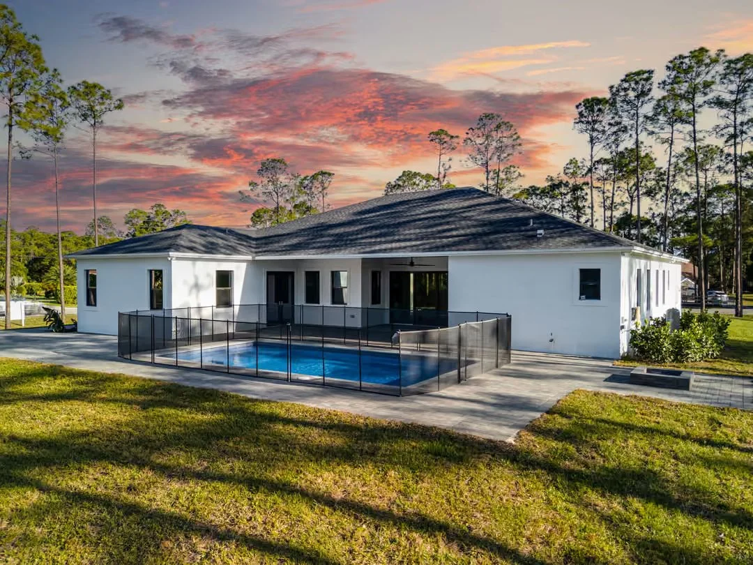 New-construction home with pool at sunset