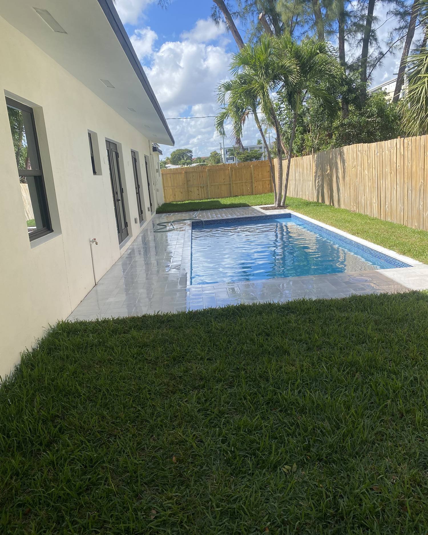 Pool with marble deck in a side yard