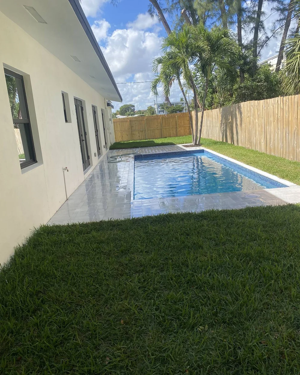 Pool with marble decking in a side yard