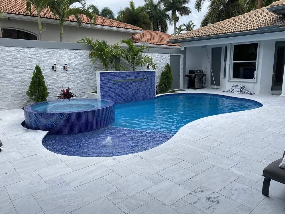 Freeform pool with raised spa and tiled water wall