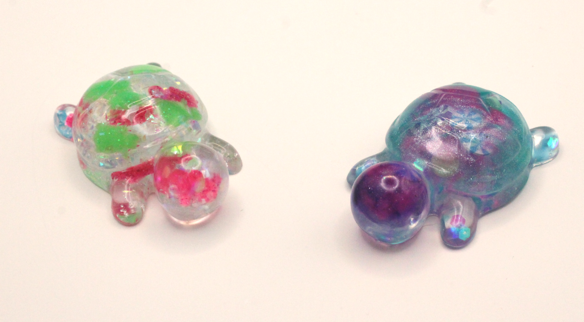 a resin turtle full of turtles and a resin turtle with candy glitter
