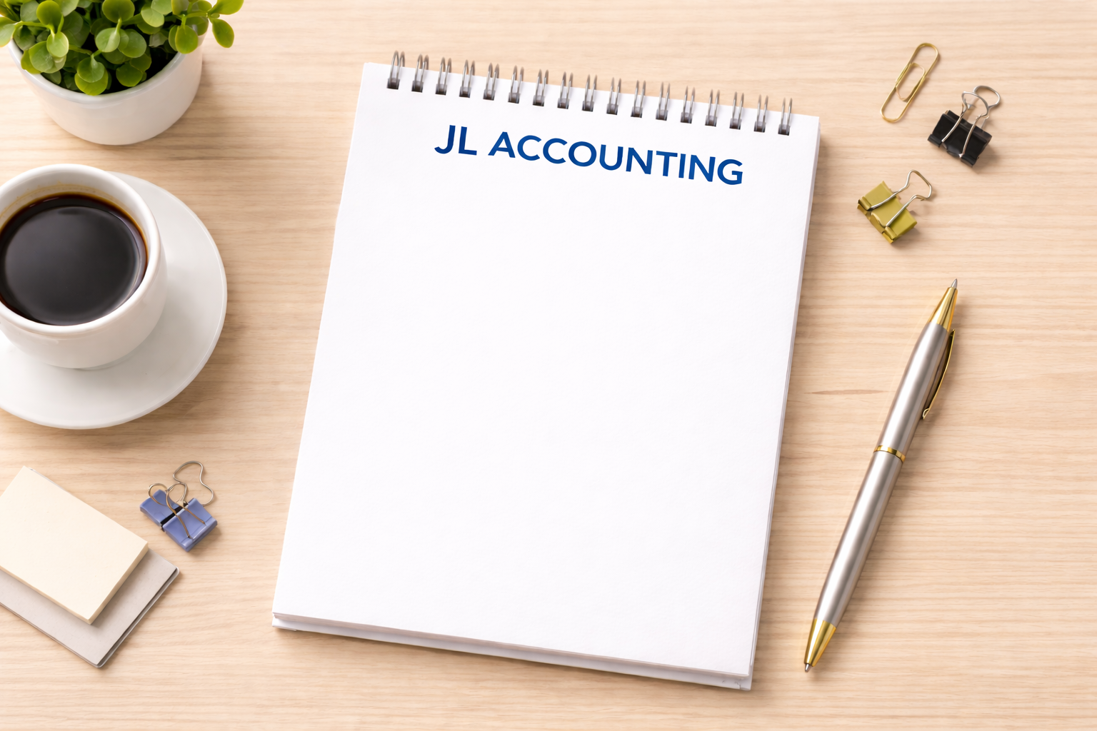 A desk with a notebook labeled 'JL ACCOUNTING', a silver and gold pen, a cup of black coffee on a saucer, a small potted plant, and various paper clips and sticky notes.