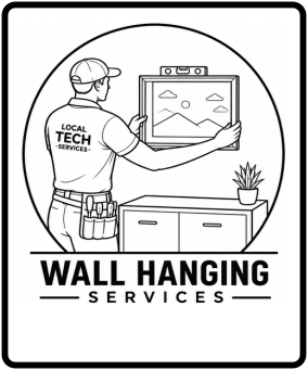 A technician with a shirt reading 'Local Tech Services' hanging a picture frame on a wall above a cabinet, with a potted plant on top of the cabinet.