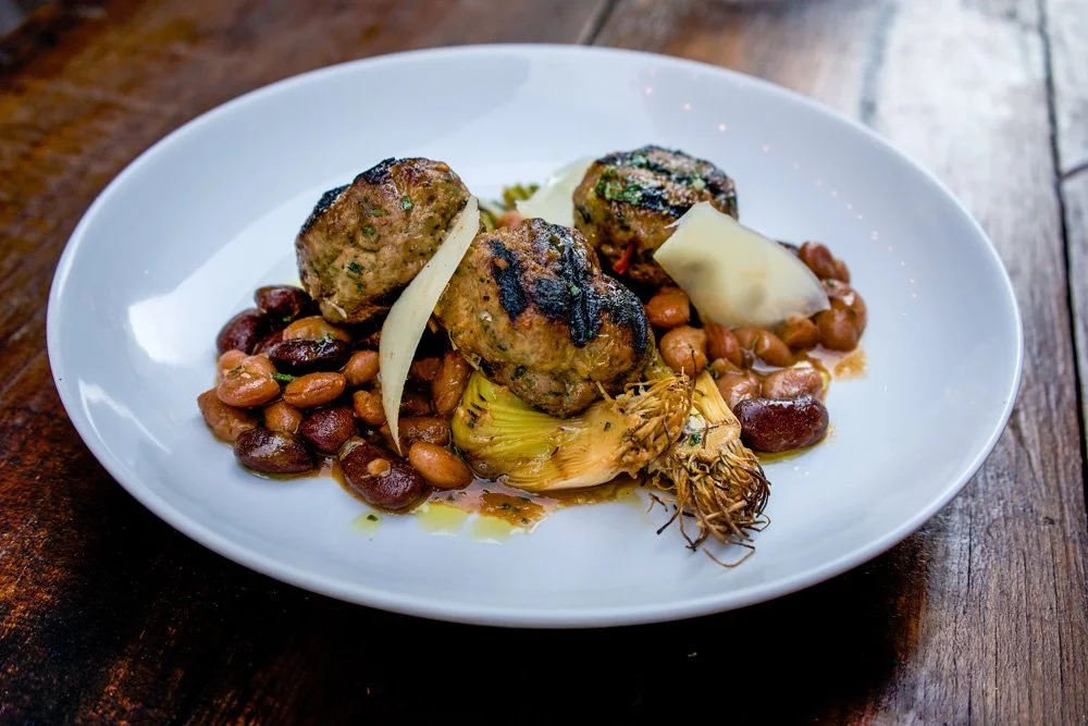 Grilled Pork and Beef Meatballs with Heirloom Bean Ragù, Braised Leeks, and Shaved Grana Padano.