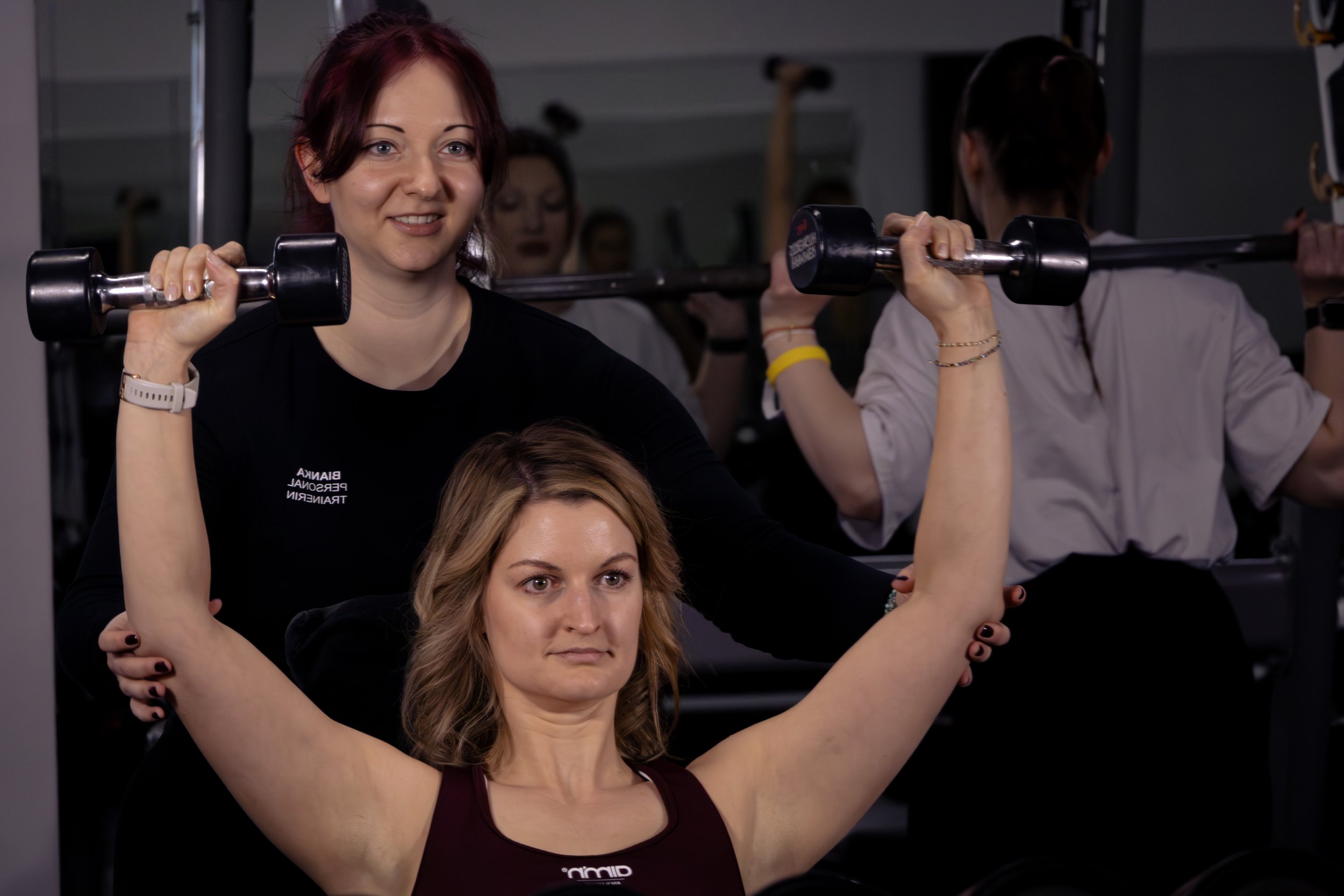 Menschen beim Gewichtheben in einem Fitnessstudio.