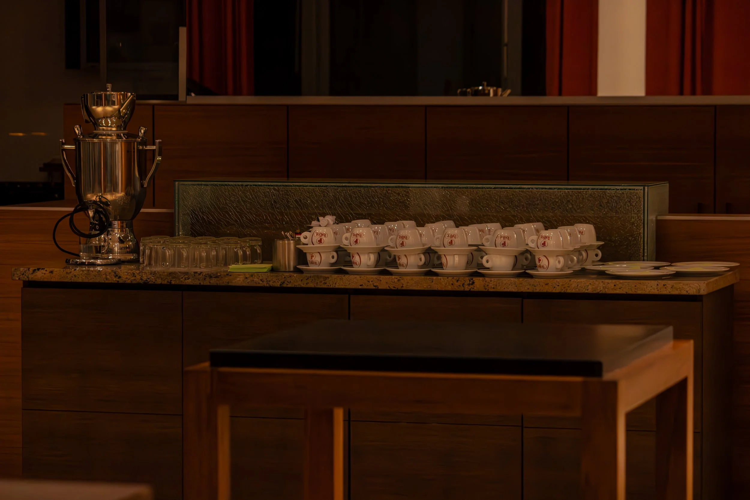 Eine Barista-Station mit Kaffeemaschinen, Tassen und Gläsern in einem Restaurant oder Café.