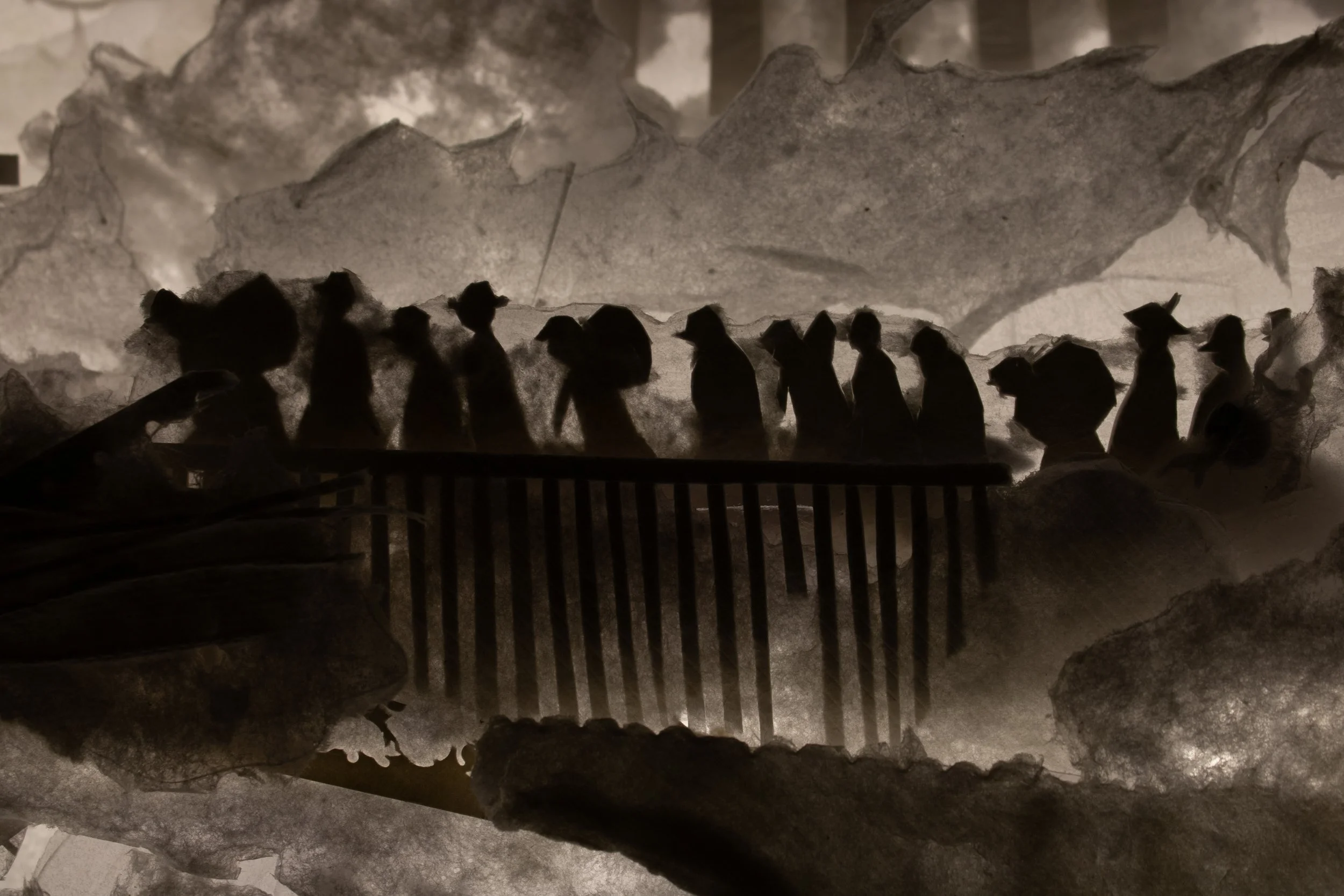 Schwarze Silhouetten von Vögeln, die auf einem Geländer sitzen, vor einem Hintergrund aus großen, zerknitterten Papierstücken.
