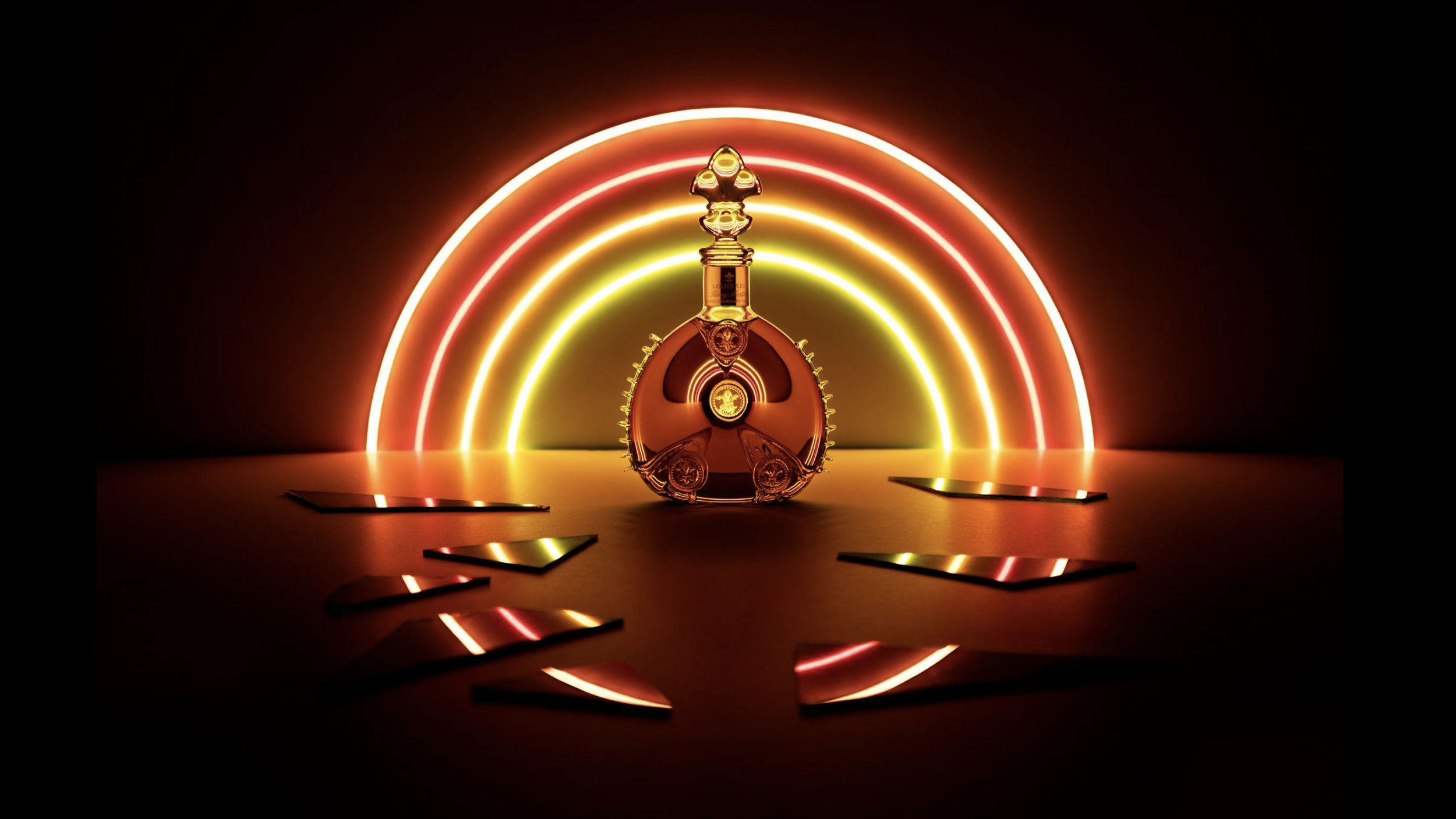 Une bouteille de parfum Louis XIII de Louis Vuitton, décorée de détails dorés, posée sur une surface sombre, avec un fond de lumières néon en arcs rouges, oranges et jaunes, créant une ambiance élégante et moderne.