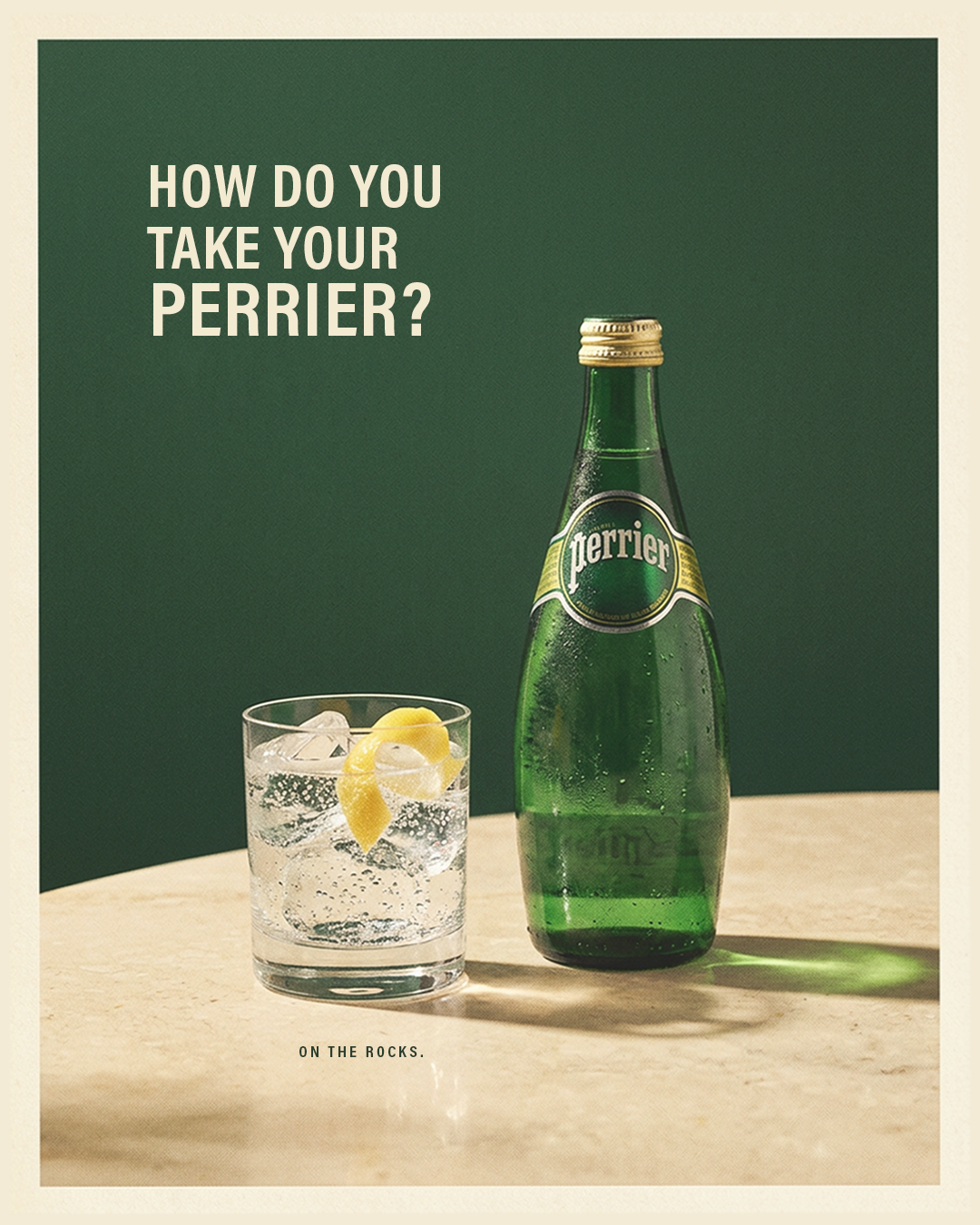 A bottle of Perrier sparkling water and a glass with ice and a lemon twist, on a light-colored surface with a green background, with the text 'How do you take your Perrier?' and a small caption 'On the rocks'.