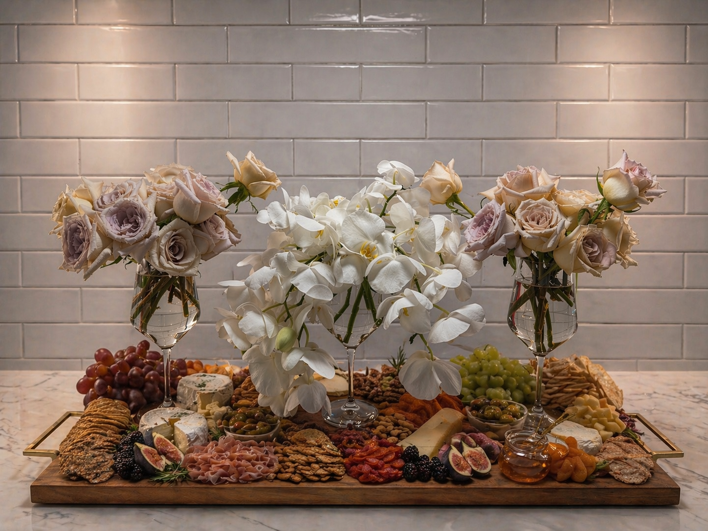 Elevated floral tablescape featuring orchids and roses styled in modern glass vessels for luxury entertaining and event design.