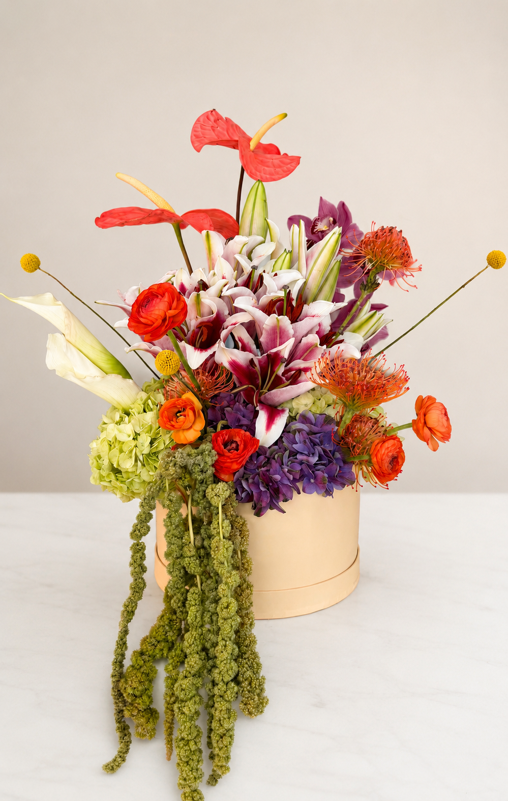 Editorial floral arrangement with lilies, orchids, hydrangeas, and cascading amaranths for luxury events and interiors.