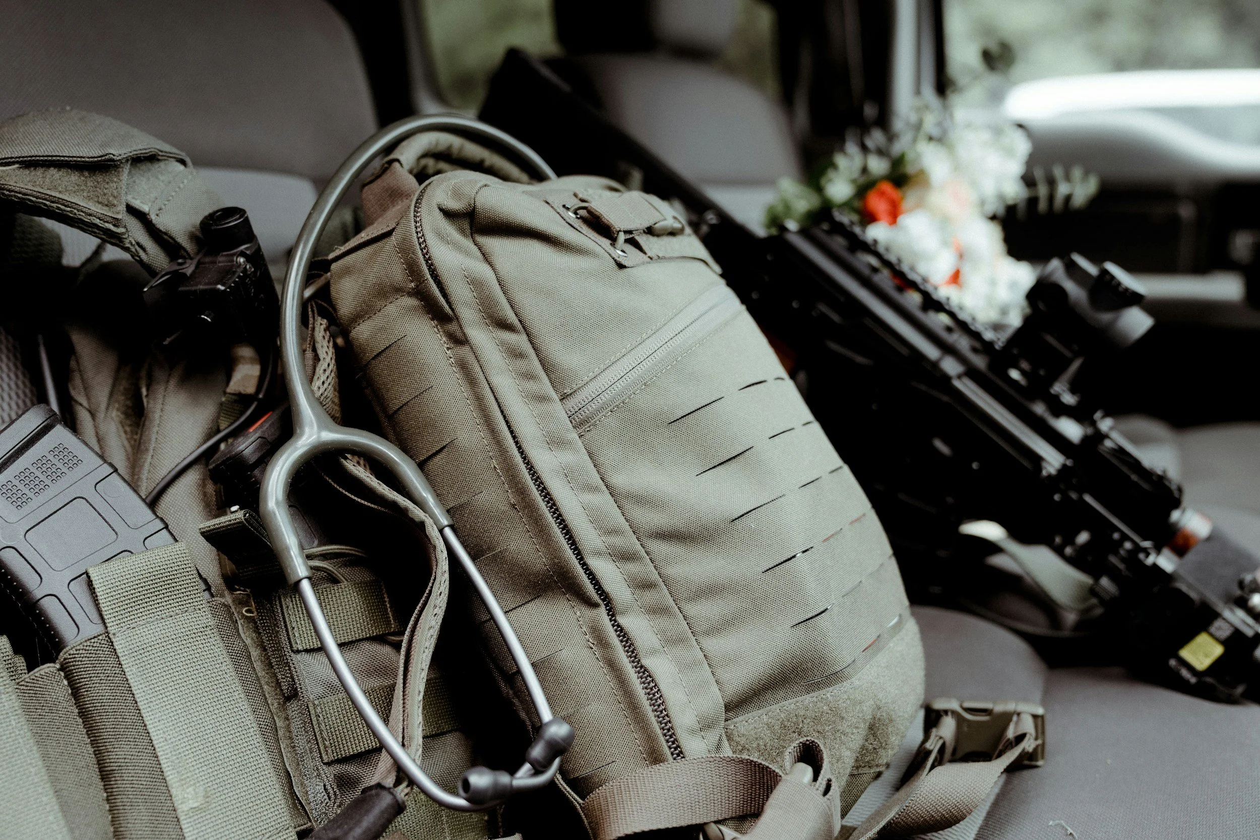 Inside an aircraft cockpit, with a beige backpack, a laptop, headphones, and a flower arrangement on the dashboard.