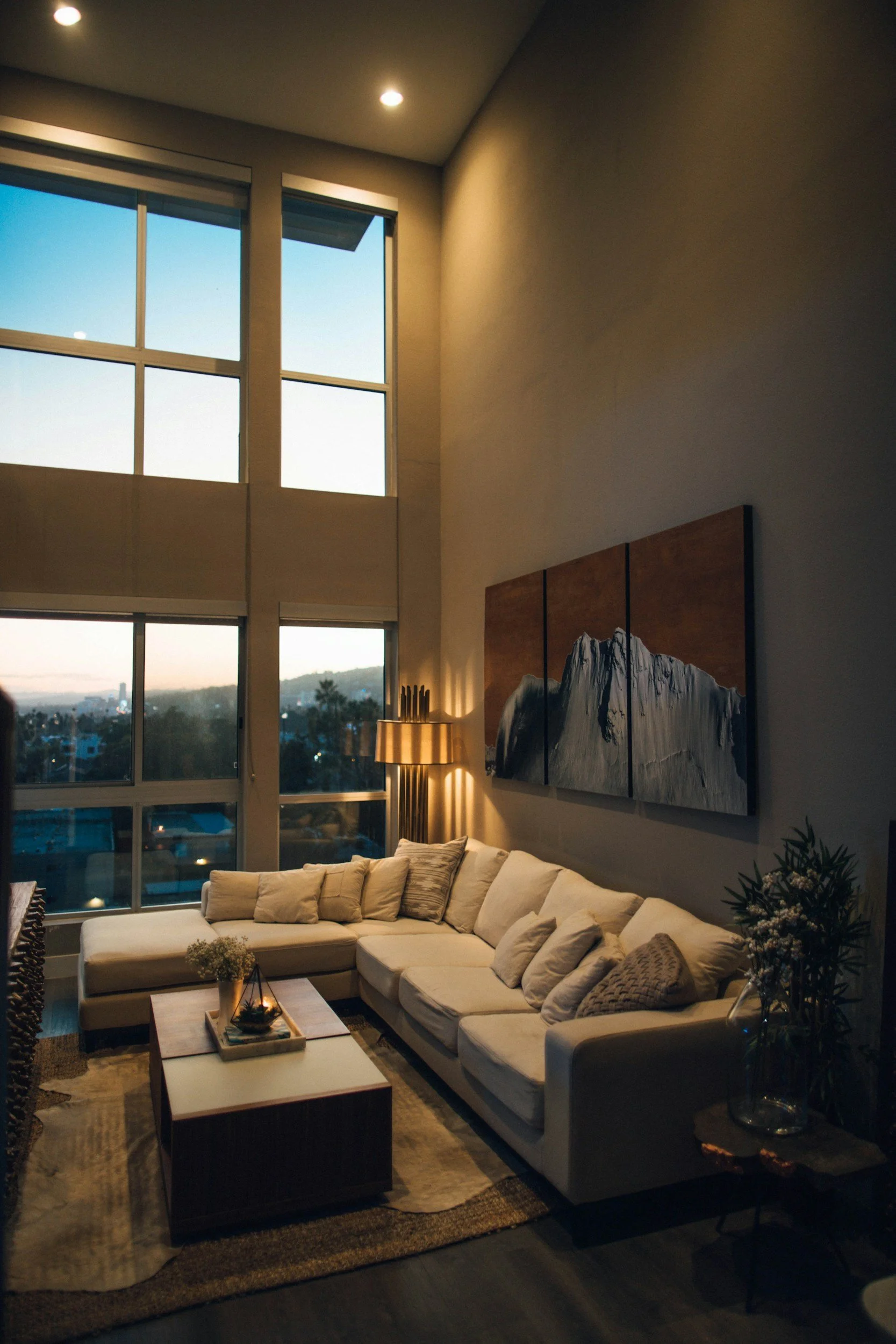 modern-living-room-with-large-windows-and-city-view-at-night.jpg