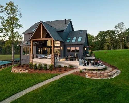 modern-farmhouse-with-black-metal-roof-covered-patio-and-fire-pit-backyard.jpeg