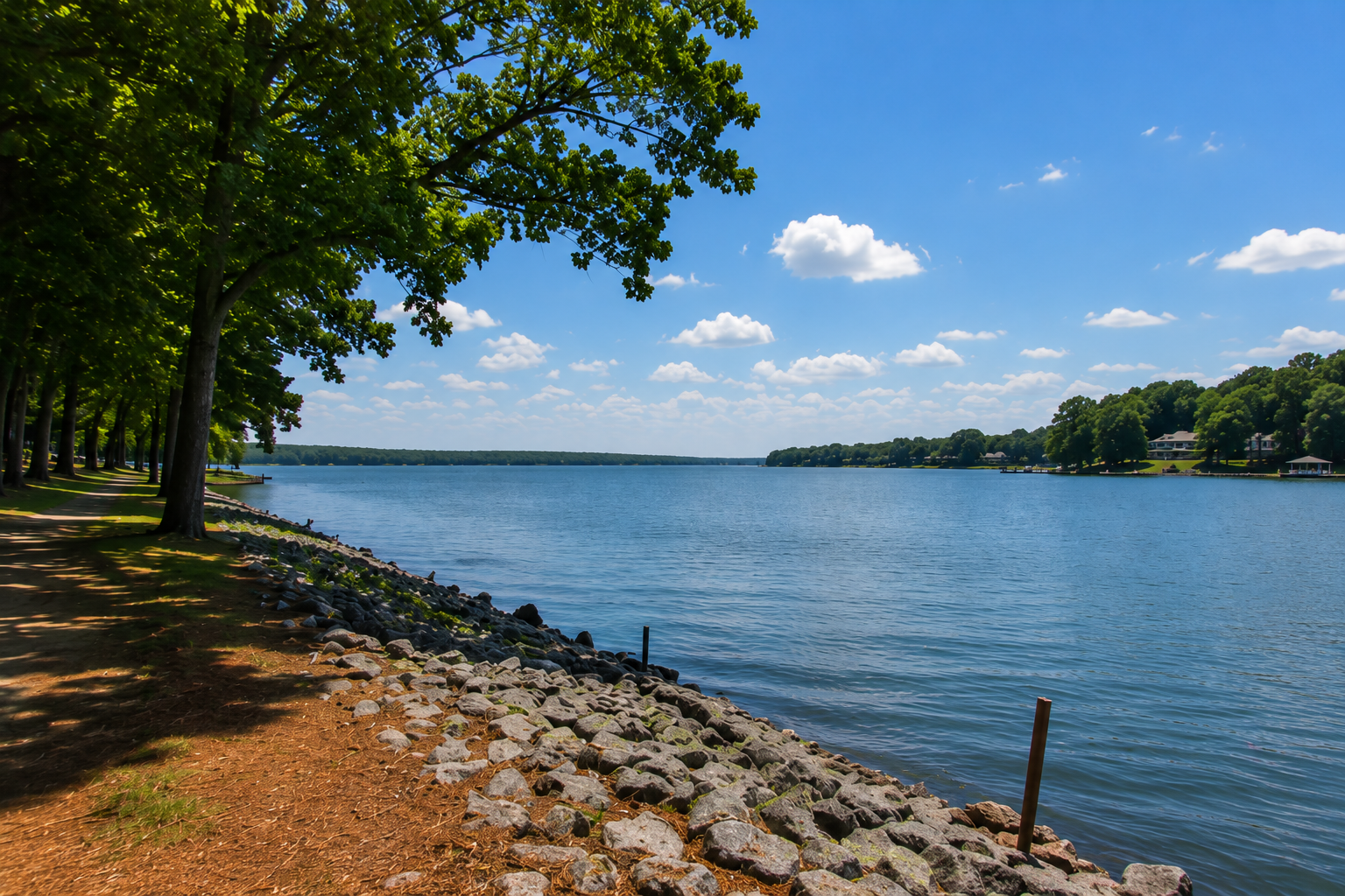charlotte-nc-lake-shoreline-with-riprap-rocks-and-green-trees.png