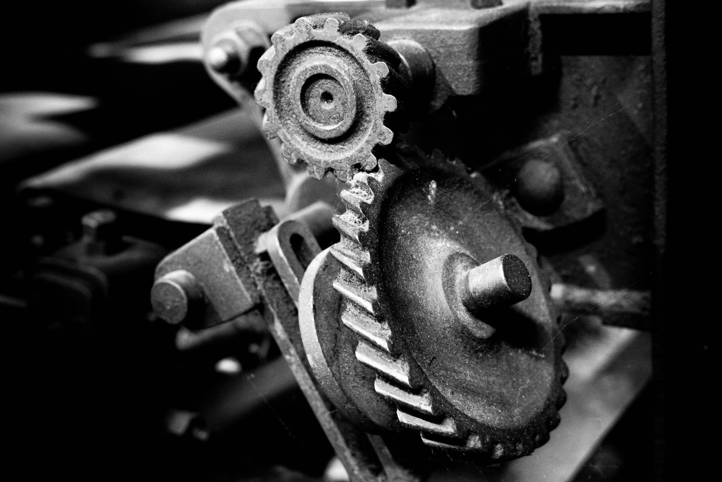 Close-up of metallic gears in a mechanical device in black and white.