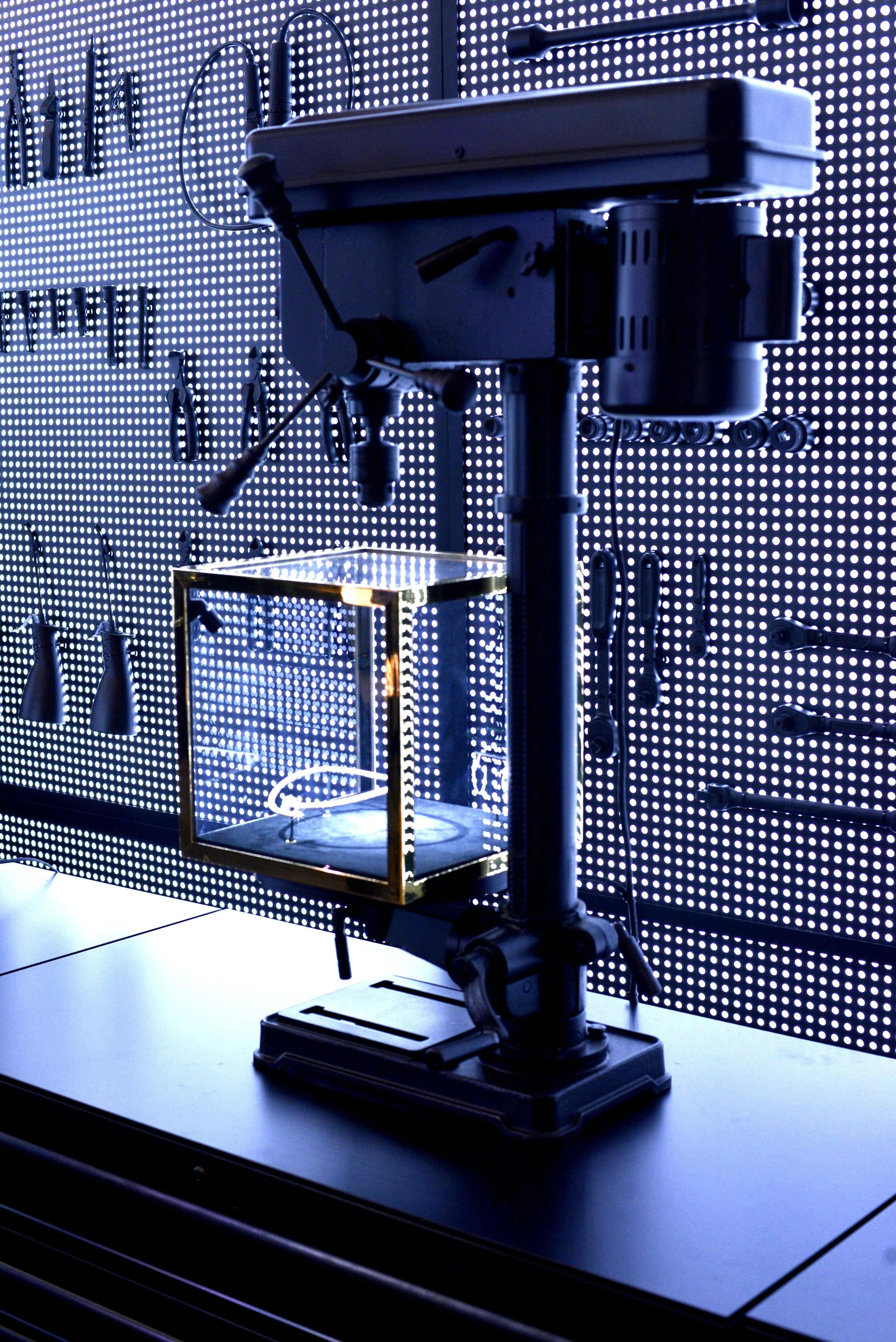 A robotic arm in a laboratory with a digital LED background display, possibly used for research or technological demonstrations.