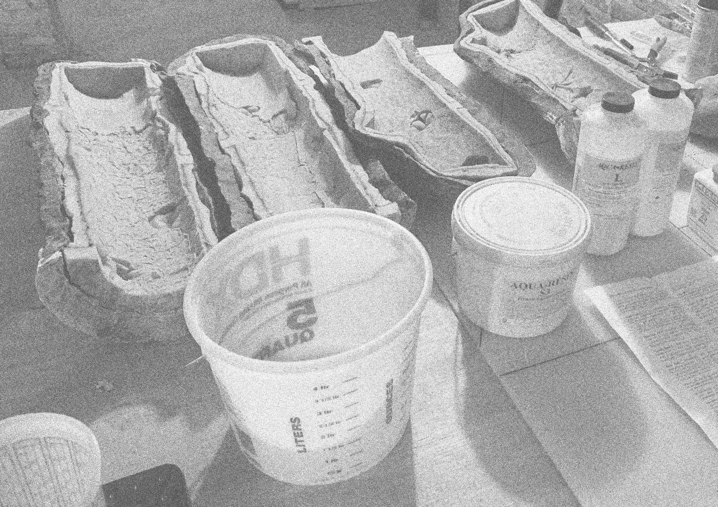 Various cans and containers, some with labels, are arranged on a surface, including a large tub or container and a few smaller cups or jars.
