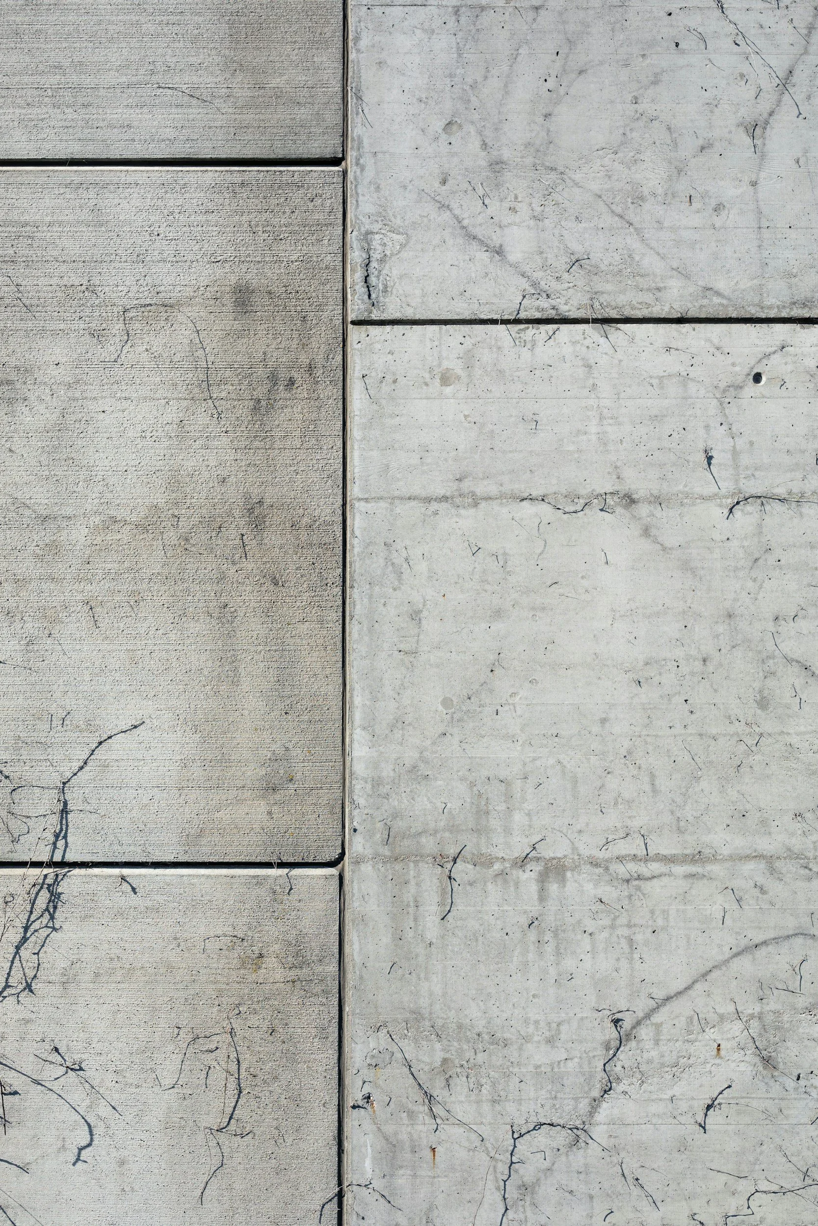Close-up view of concrete and stone wall surfaces with cracks and textures.