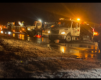 Flooded street at night with emergency vehicles and flashing lights