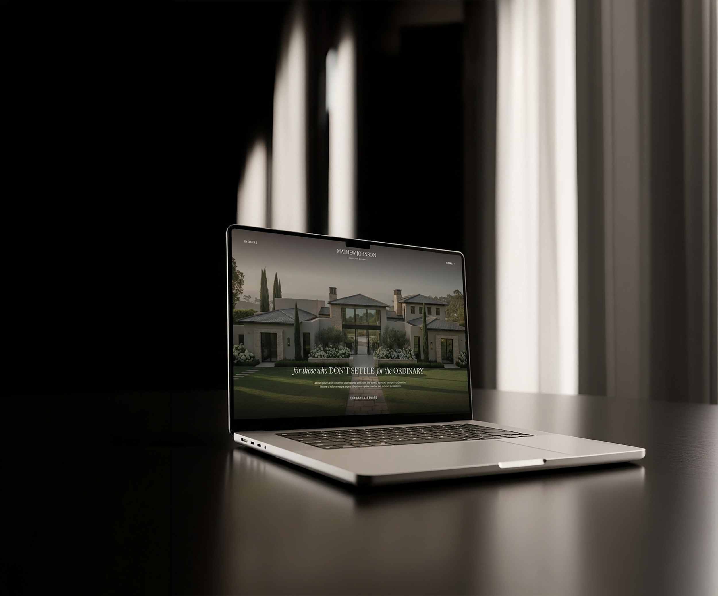 Laptop on a desk displaying a website about a modern house, with sunlight coming through curtains in the background.