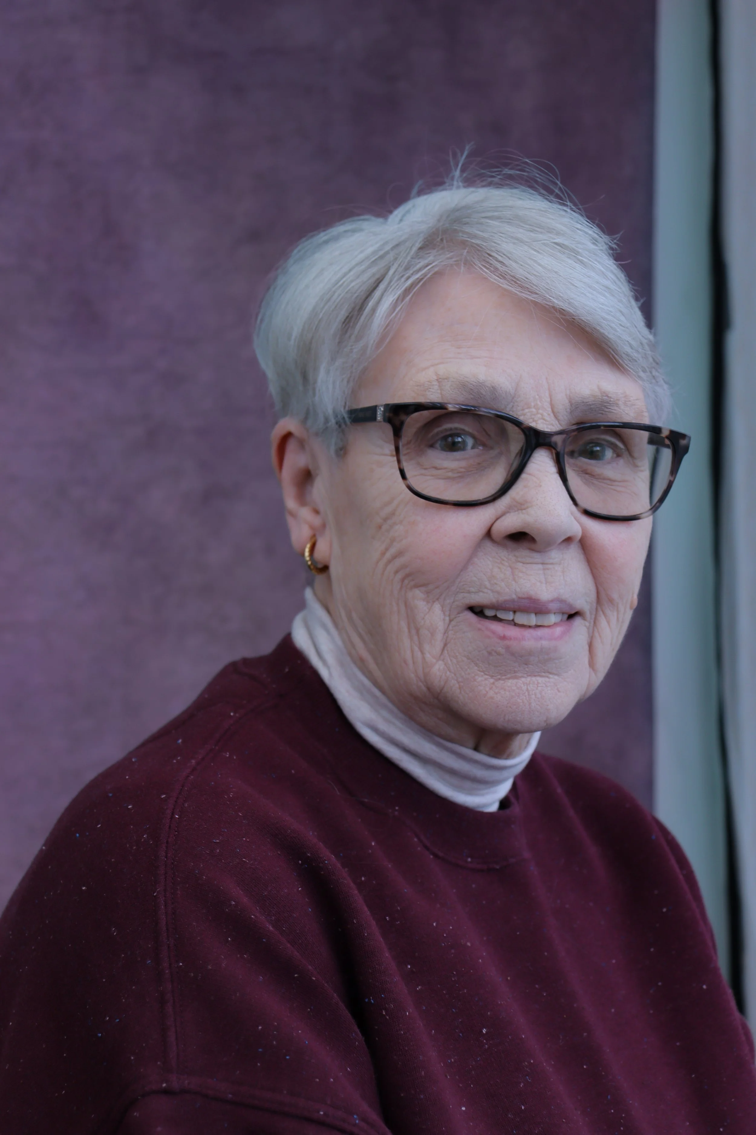 Studio headshot of a mature female actor using natural light, neutral background