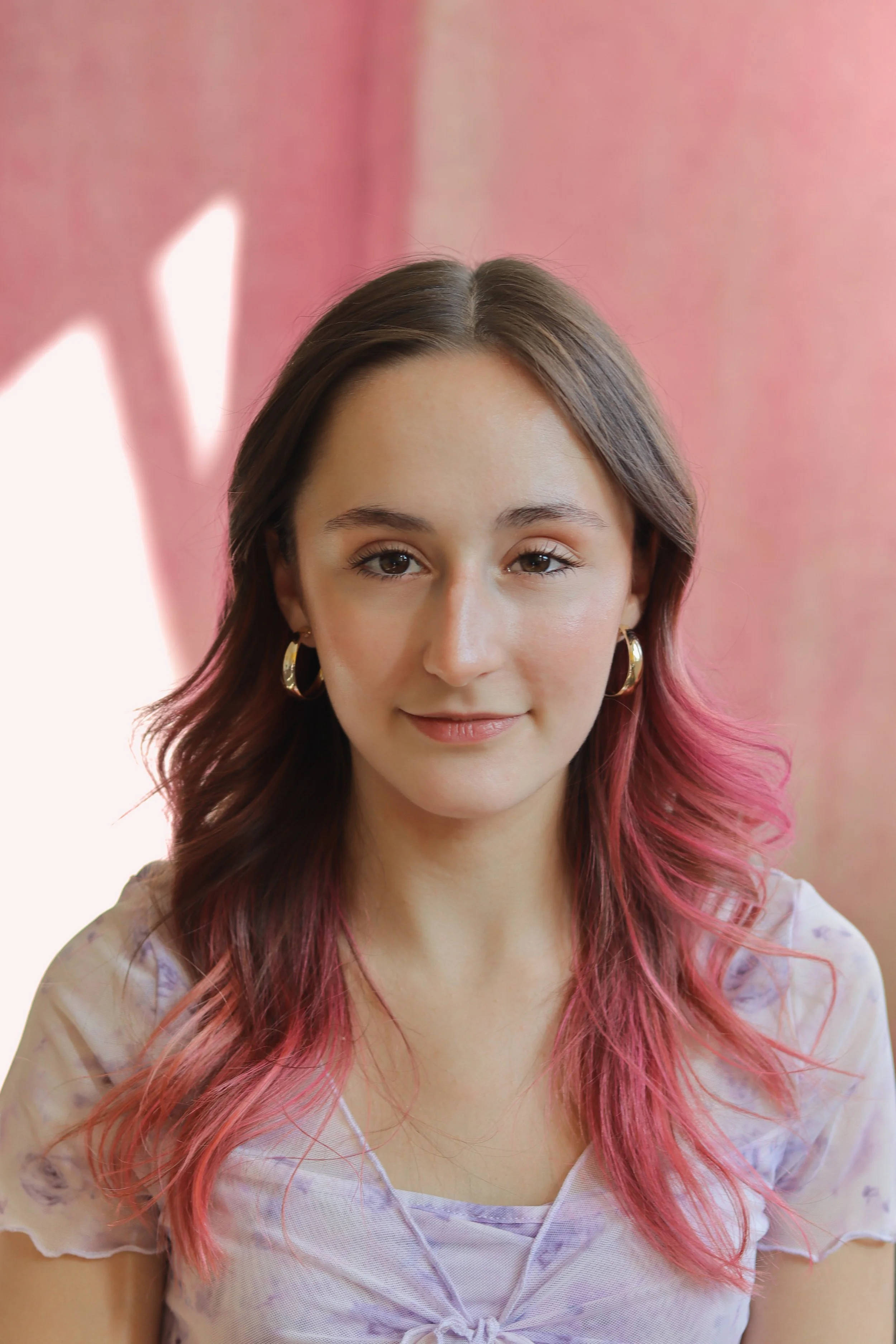 Eliza Lovely is a musical theatre actor with pink hair, her actor headshot in Sheffield has a pink background