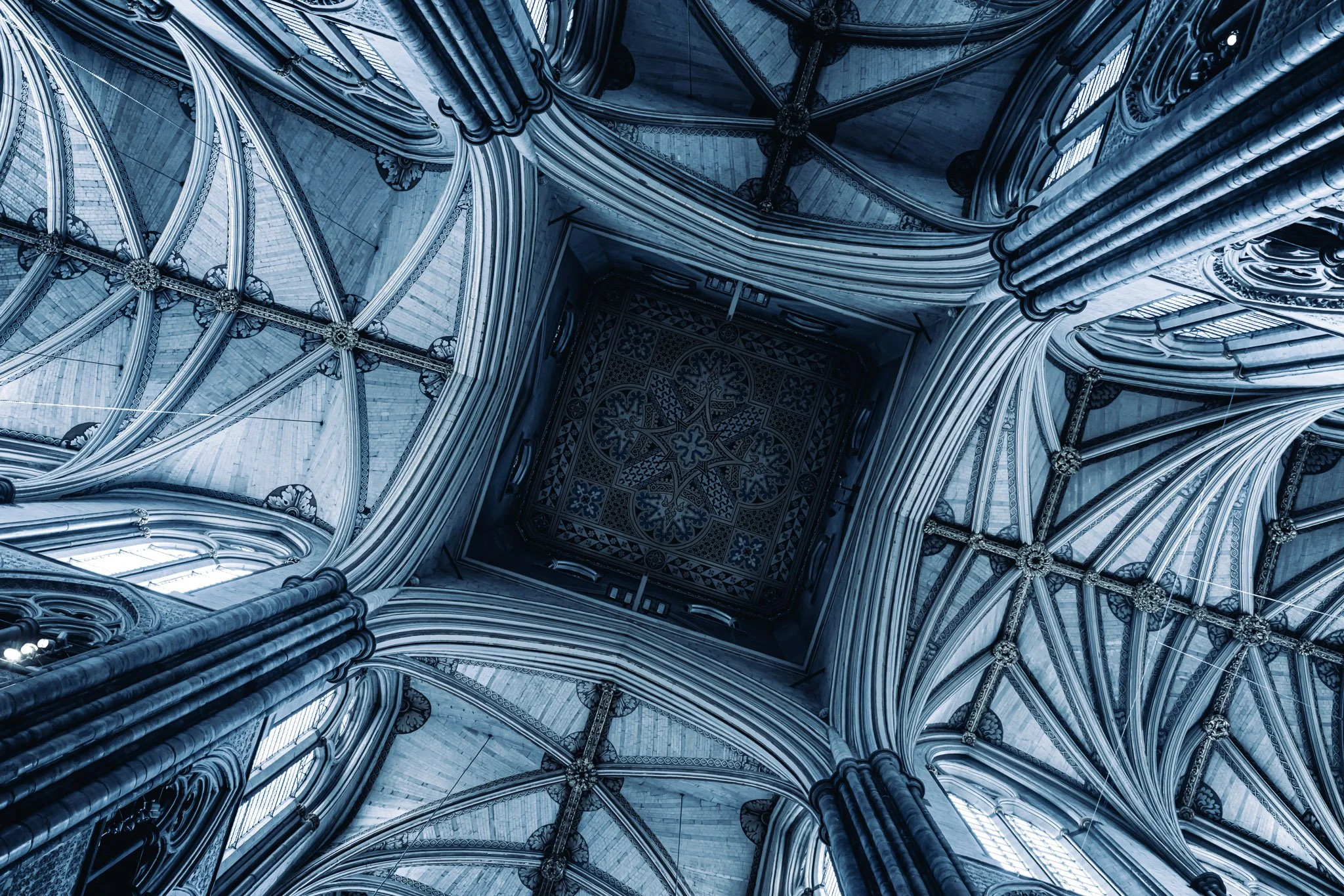 Interieur van een gotische kathedraal met hoge gewelven en detaillering in de stenen pijlers en plafond, getoond vanaf de vloer naar boven