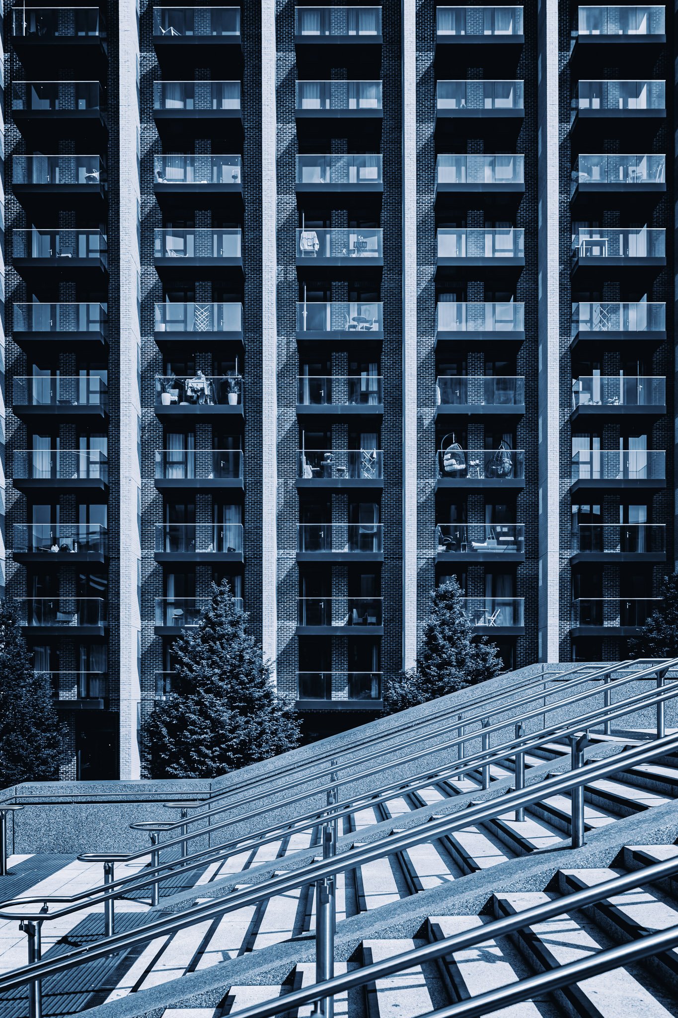 Moderne woongebouw met meerdere verdiepingen, balkonnetjes en ramen, blauwe filter