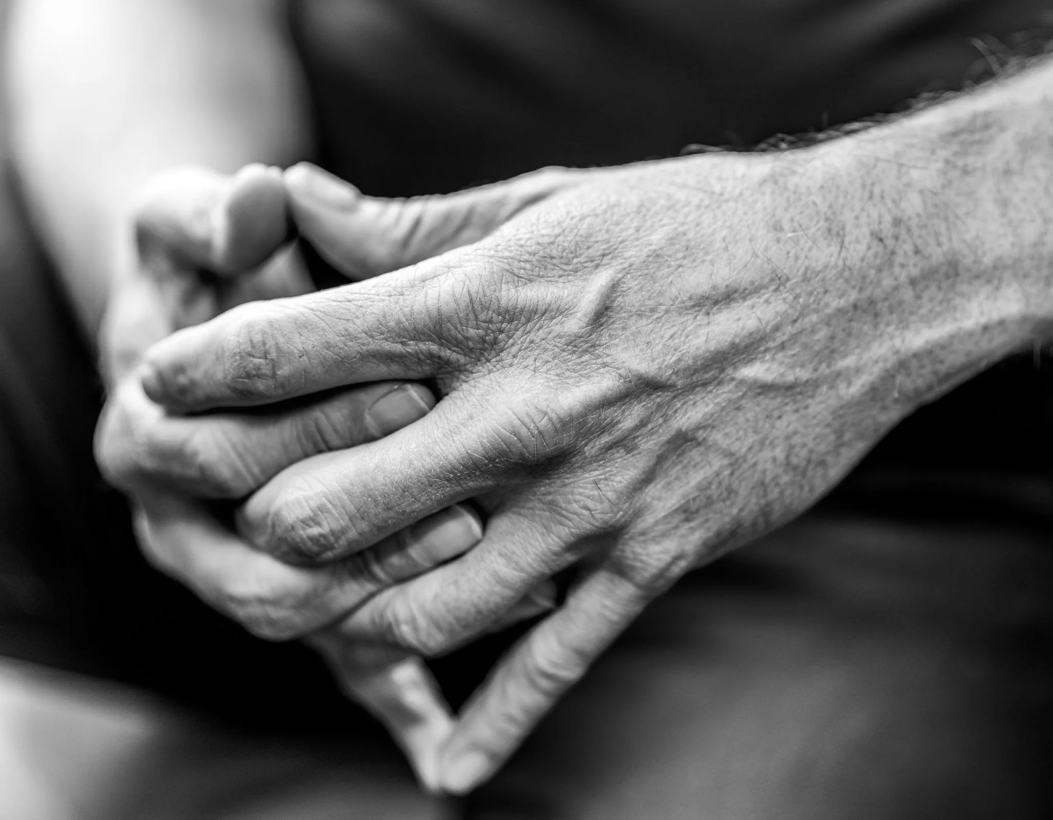 Zwart-wit close-up van twee mensen die elkaar de hand schudden.