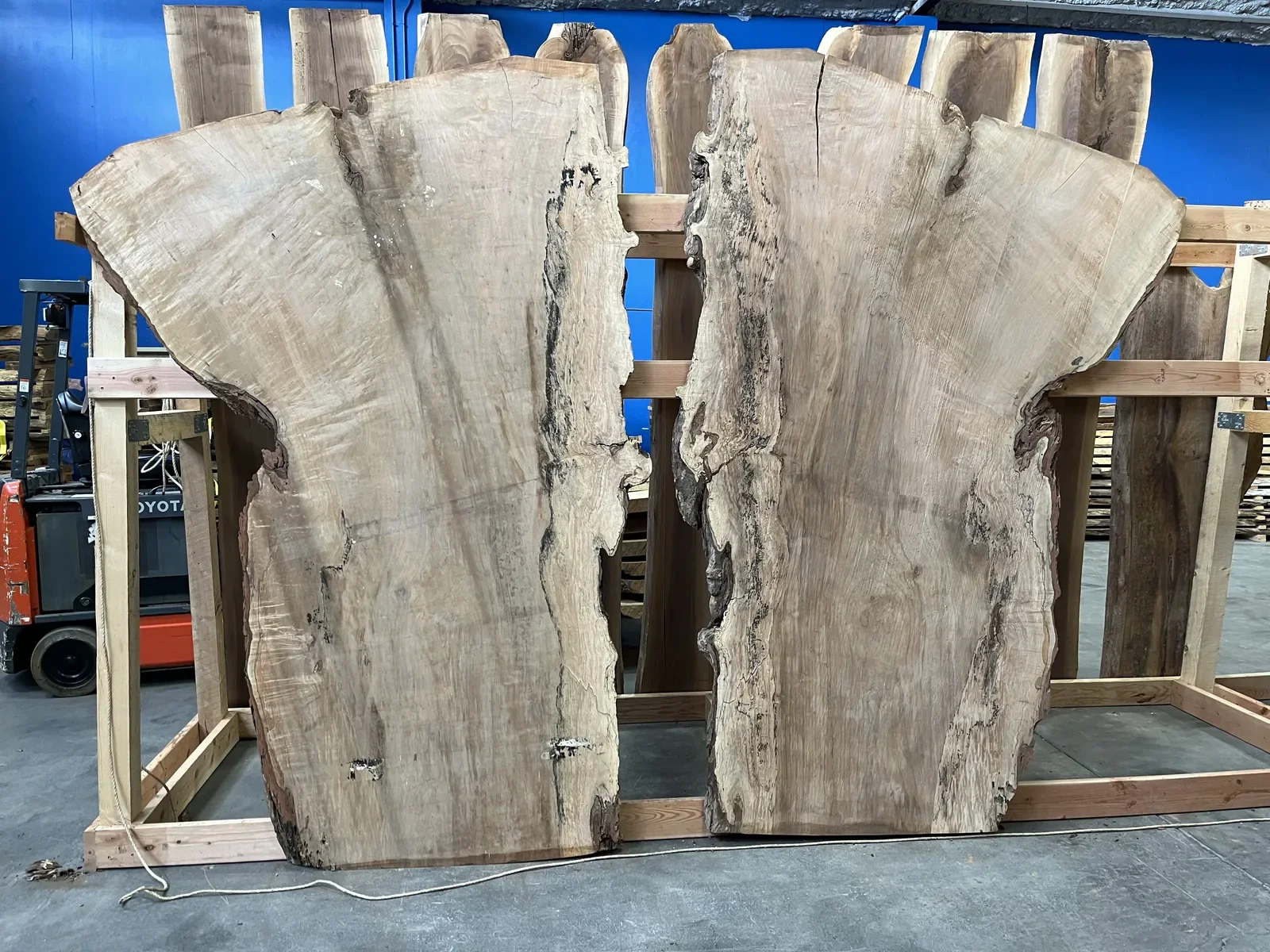 Freshly milled live edge hardwood slabs on storage racks in the Vermont Tree Goods warehouse