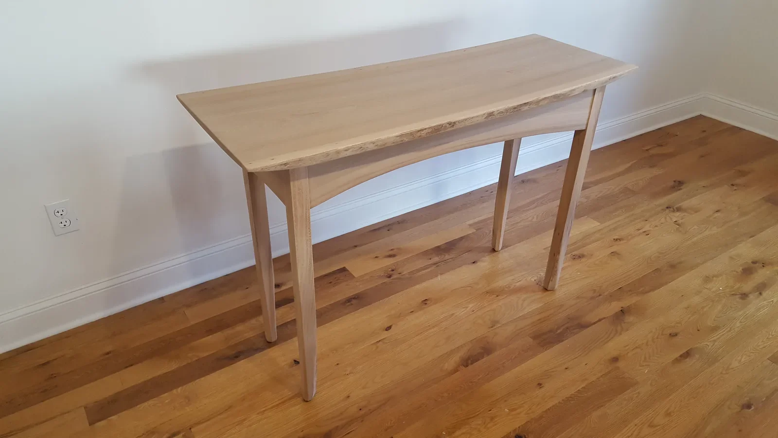 Custom live edge hardwood desk and console table with tapered wood legs, finished in natural maple