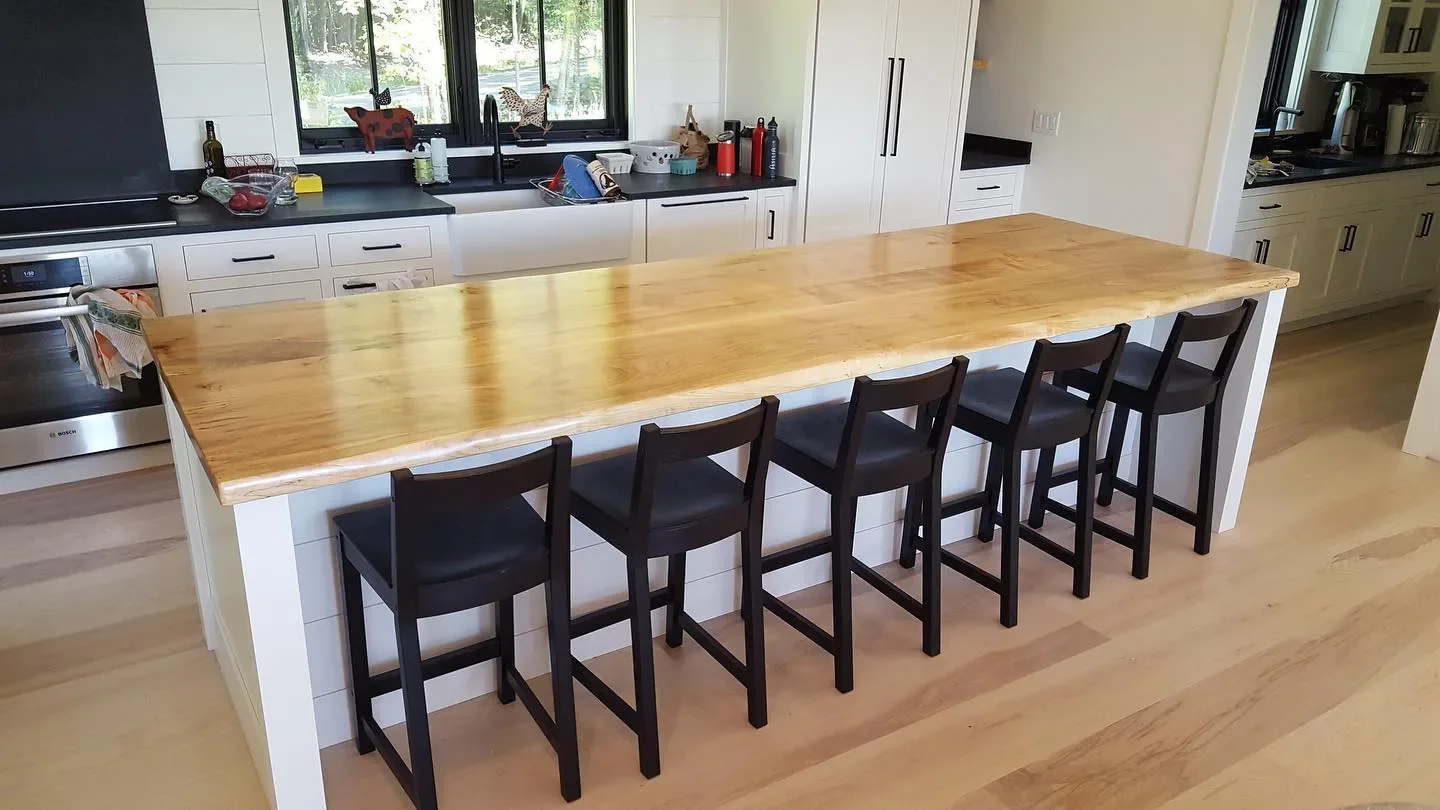 Extra-wide live edge hardwood island countertop on a shiplap base, seating five, in a modern farmhouse kitchen
