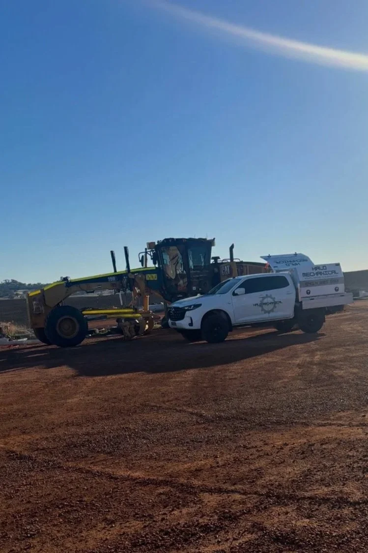 White ute and yellow grader in Perth, Australia.